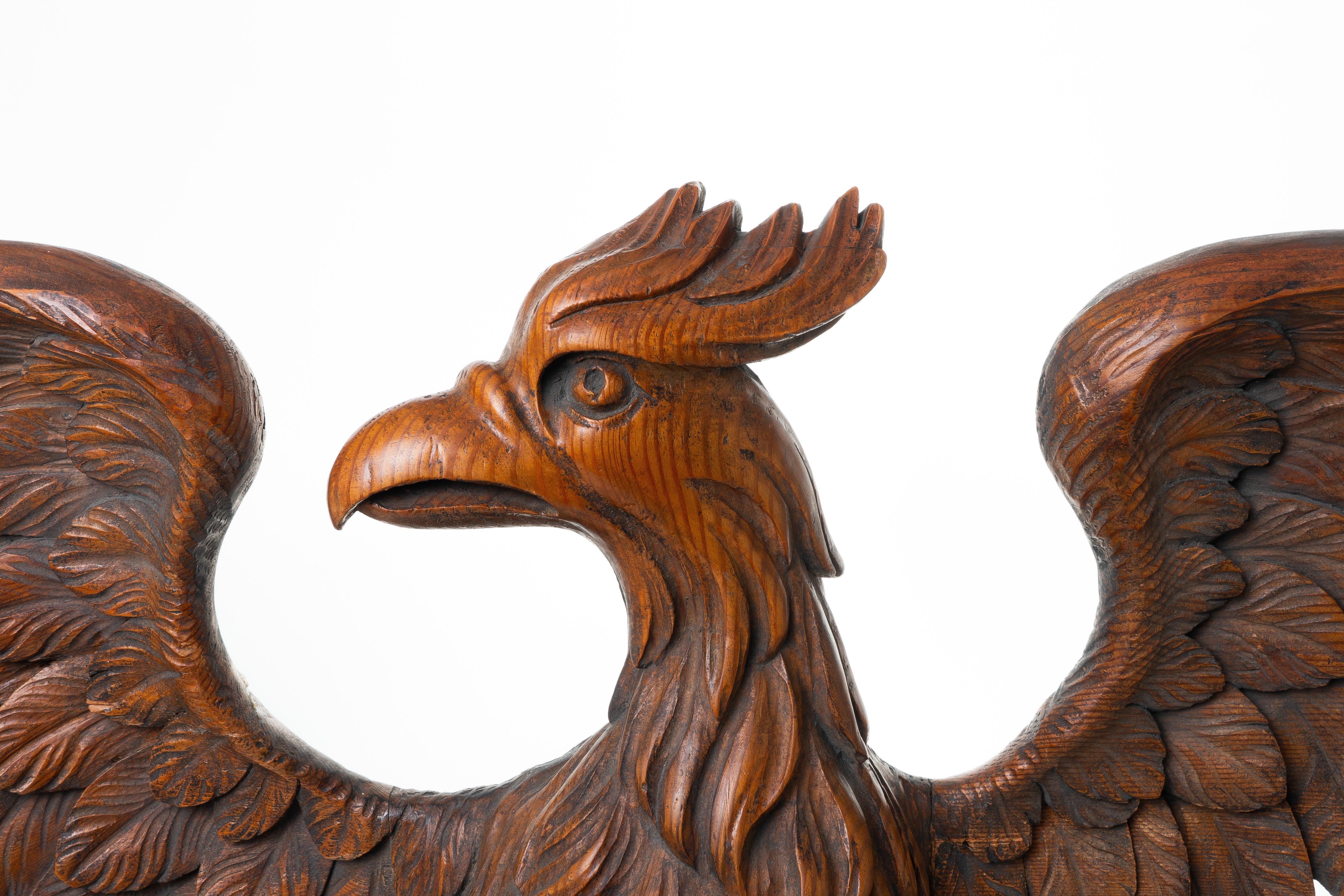 Carved wooden eagle with wings spread, standing on a rocky ledge. An architectural embellishment, the work is carved in Scotch pine with traces of the original paint on the rocky base. The carving is fitted to a custom wall mount bracket.

Northern