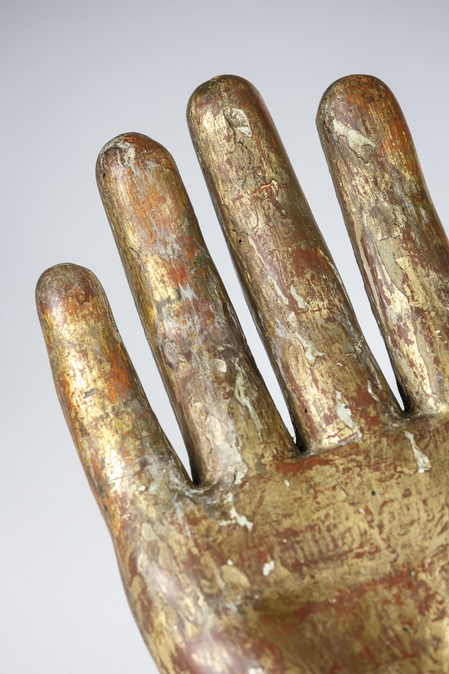 Glove Makers Trade Sign. Carved wood with the original gilded finish, weathered with lots of bole showing through the gilding. 
Original iron fitting to the reverse on the top of the wrist. A later iron fitting has also been added most likely in