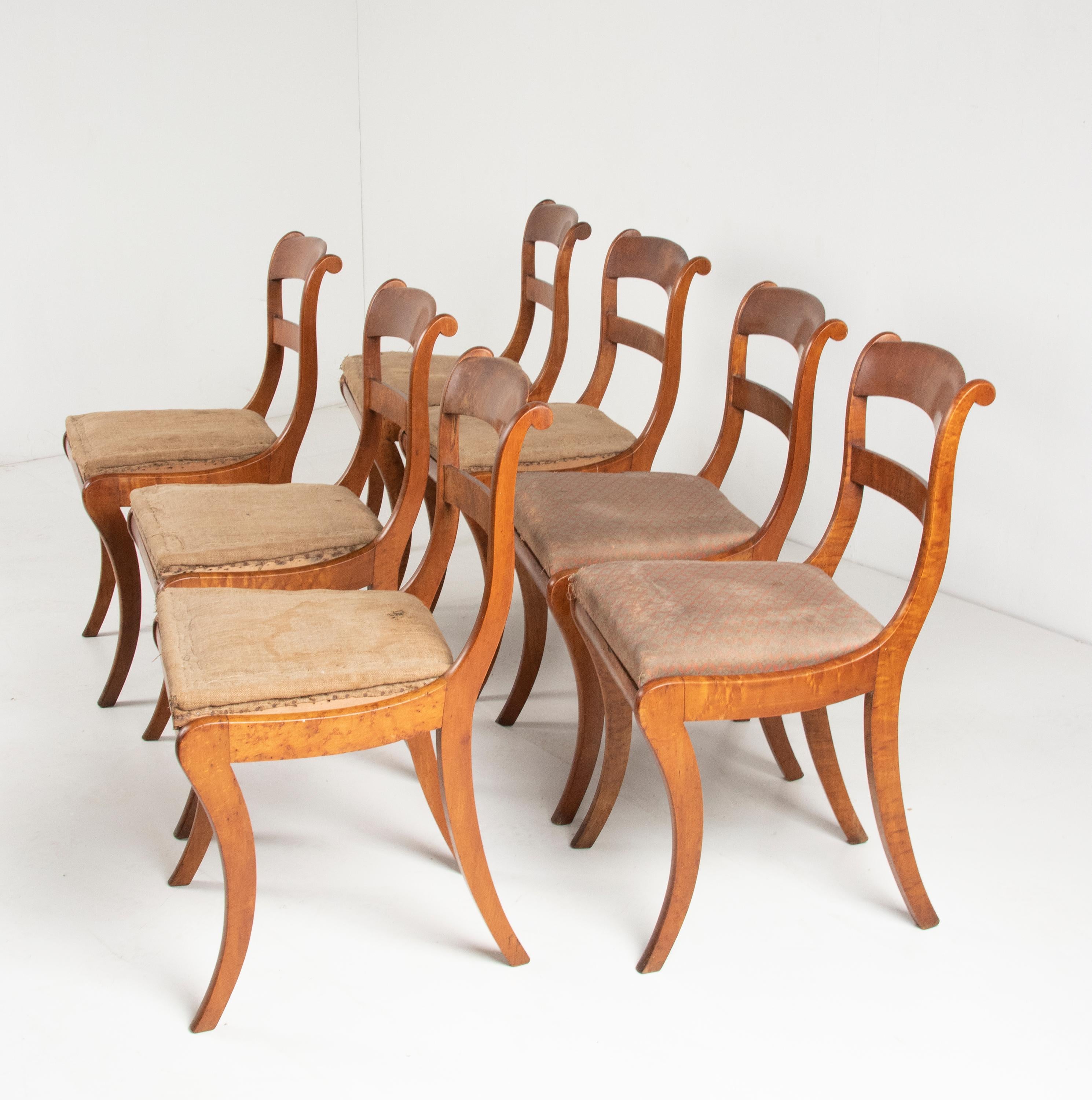 A set of seven dining chairs from the French Charles X period. Made of Bird-eye maple wood. These antique chairs have an elegant design. The curved saber legs gives the chairs a nice appearance. The chairs are constructively sturdy. The seats of the