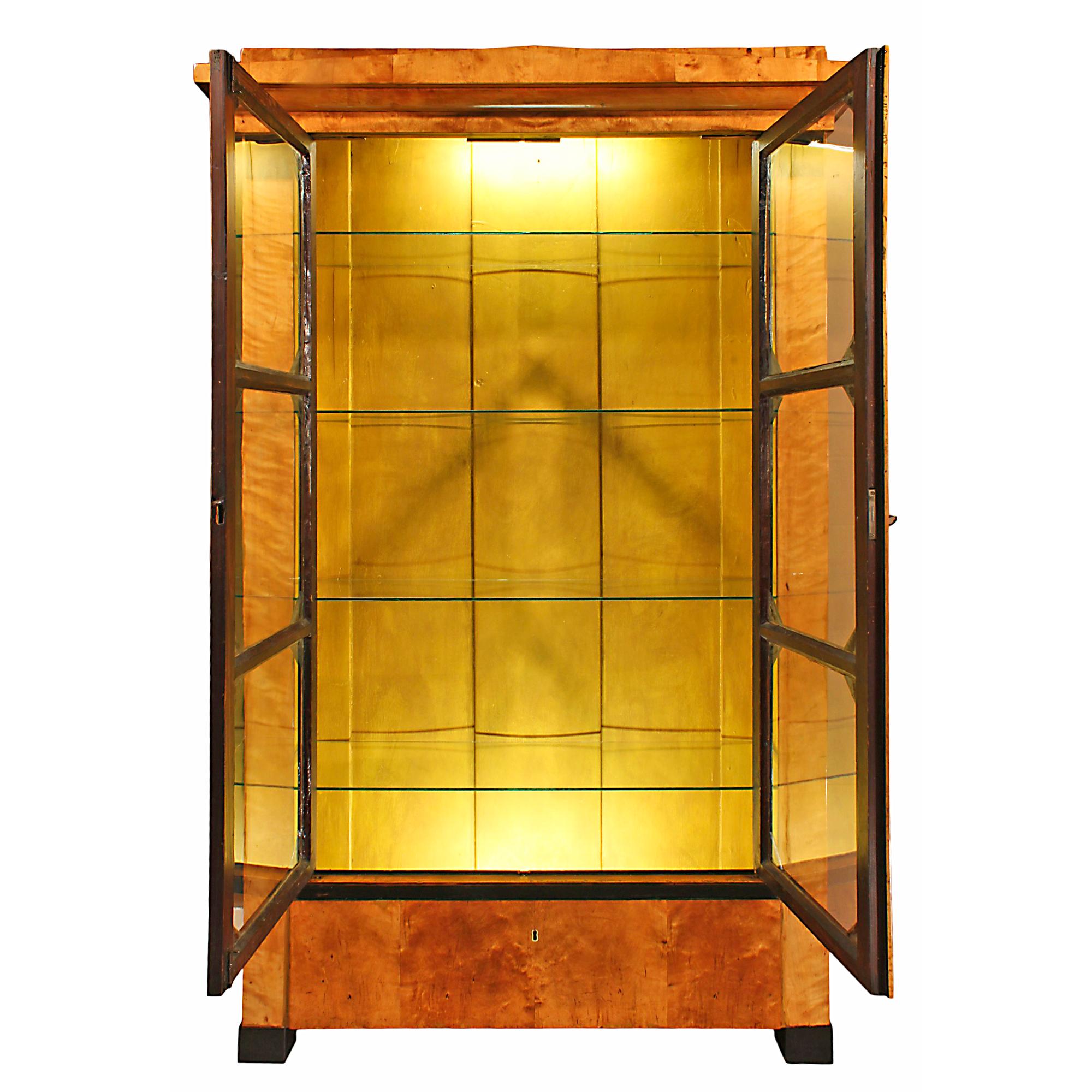 A stunning early 19th century cherry and ebony Biedermeier vitrine, circa 1850. The vitrine is raised on square ebonized feet below a faux drawer with ebony trim. Above is a pair of hand blown glass doors open to four glass shelves. The doors, with