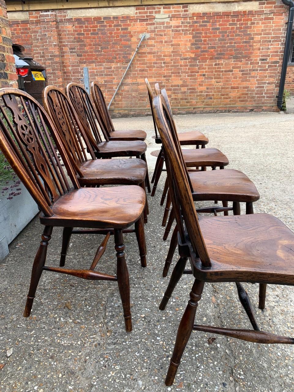 A matched set of 8 single windsor wheelback antique chairs shaped elm seat; raised on bobble turned legs united by an H-stretcher. The chairs retain an excellent color and they are very closely matched. Measures: H x 35