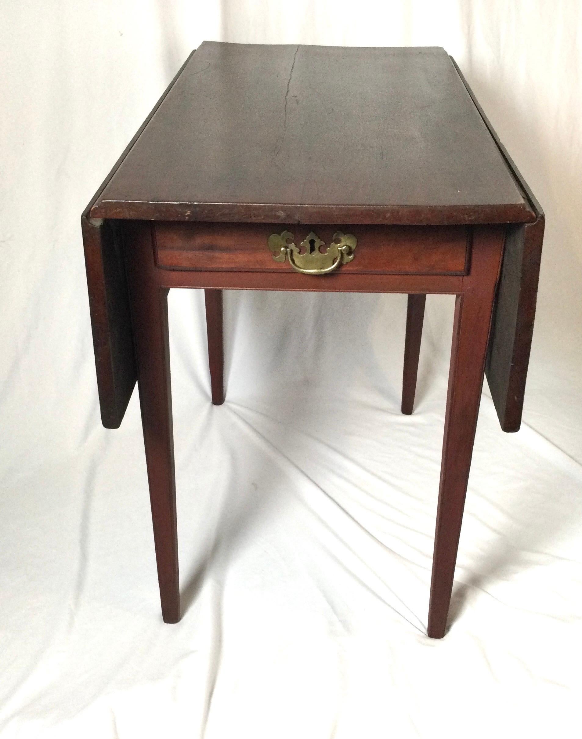 Early 19th century cherry Pembroke drop leaf table with batwing brass hardware. Old finish, has repaired small crack running 3/4 of the length of top. Measures: Closed 16