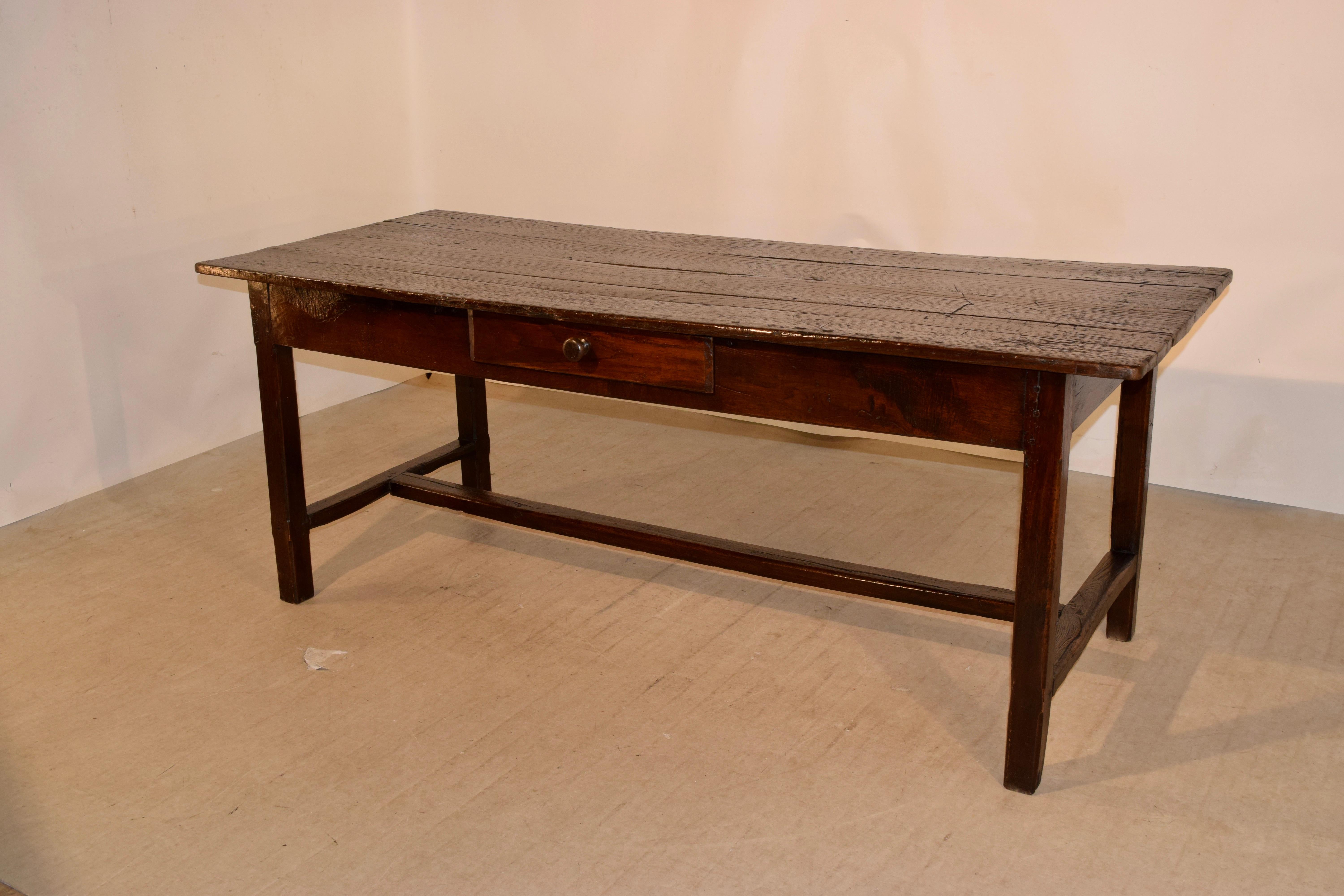 Early 19th century chestnut table from France with a plank top following down to a simple apron containing a single drawer and supported on hand turned legs joined by a cross stretcher. The apron measures 24.13 inches in height.