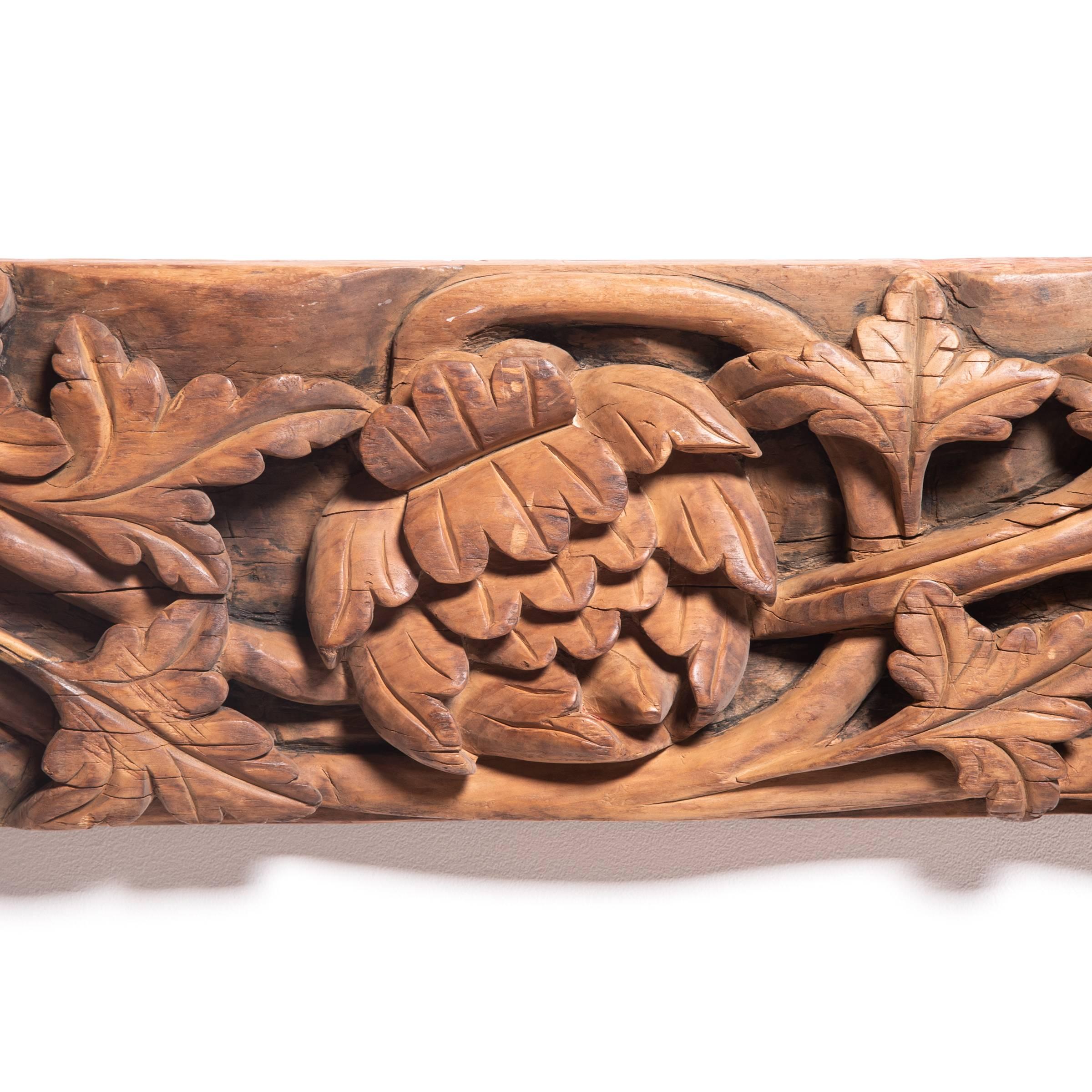This architectural valance from the early 19th century is beautifully carved in low relief, with a meandering floral design outlined by striking, high-contrast shadows. The valance is adorned with trailing ivy and several peony blossoms, symbolizing