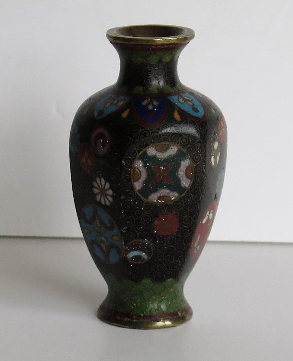 Dies ist eine sehr dekorative kleine Cloisonné-Vase aus Japan aus dem 19. Jahrhundert, der Meiji-Periode.   Die Vase hat eine gute Balusterform mit einer sechseckigen Gestalt. Sie ist aus einer Bronzelegierung mit reichen Emaillen in vielen