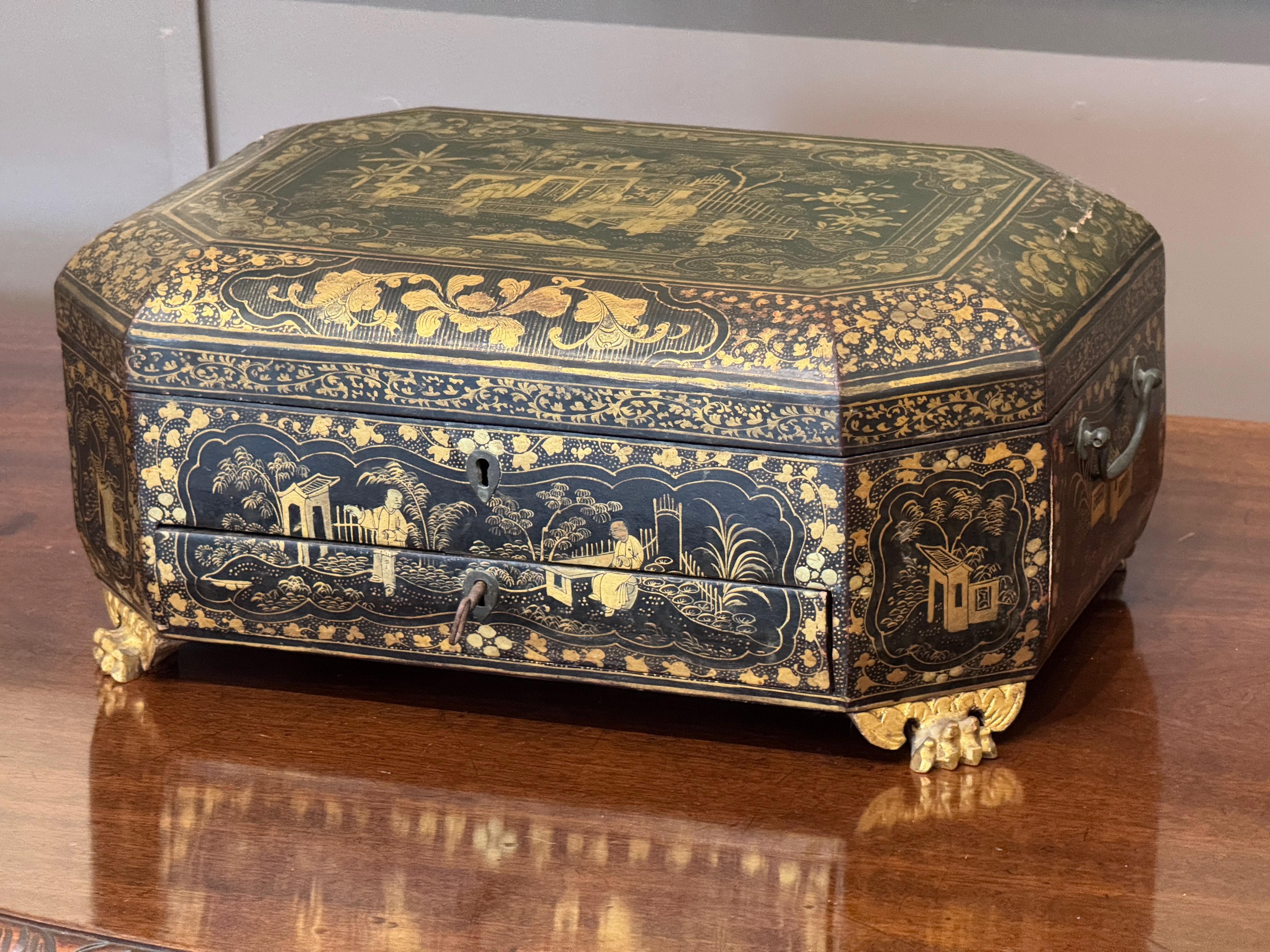 Boîte à couture ou à ouvrage d'exportation chinoise du début du XIXe siècle, richement décorée, en laque noire, avec des paysages et des personnages dorés. L'intérieur conserve une série complète d'outils et d'accessoires originaux en os sculpté