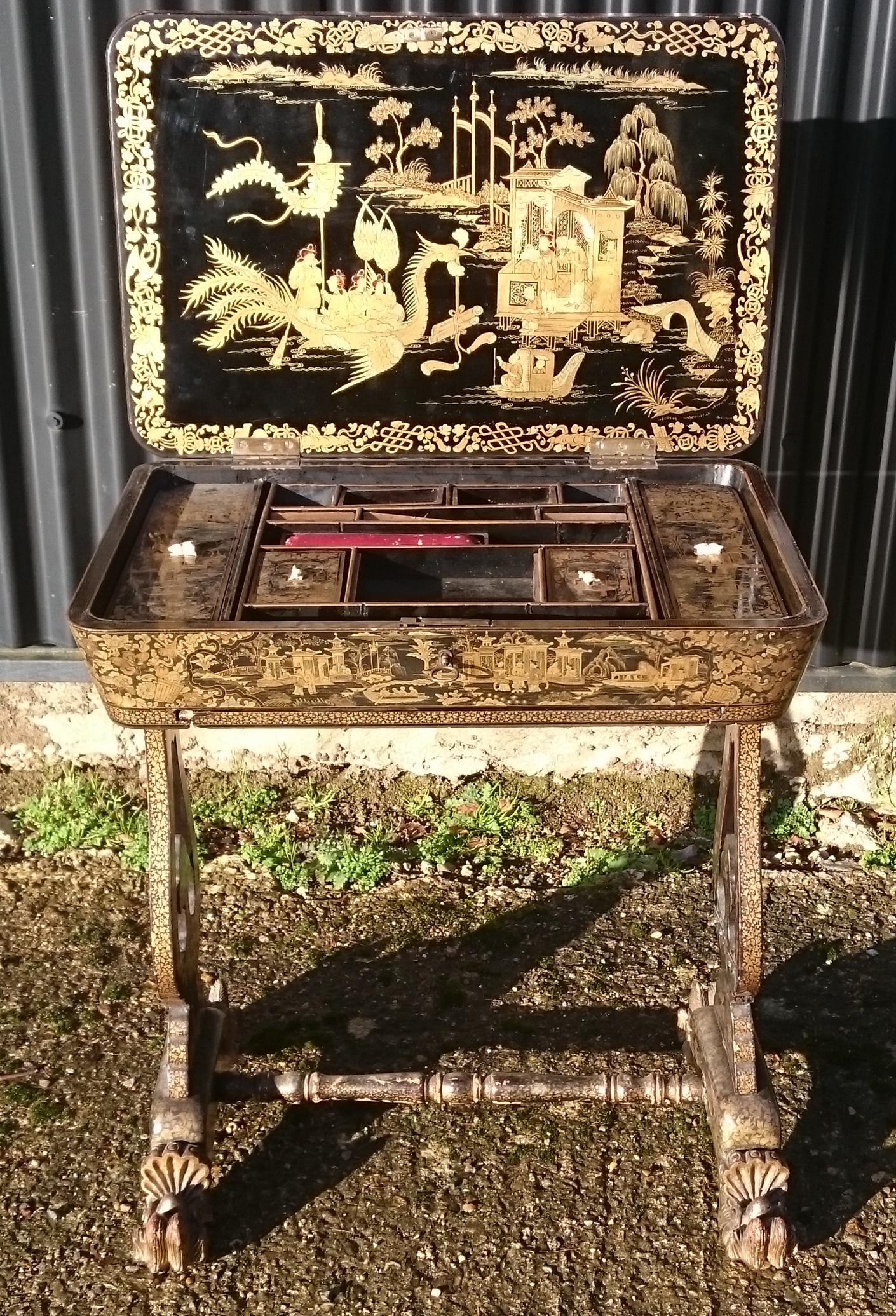 A very fine quality Chinese export lacquer work table. The lid lifts to reveal compartments for needlework tools and storage. The detail of the lacquer work is quite incredible and the whole table is profusely covered, even the inside of the legs