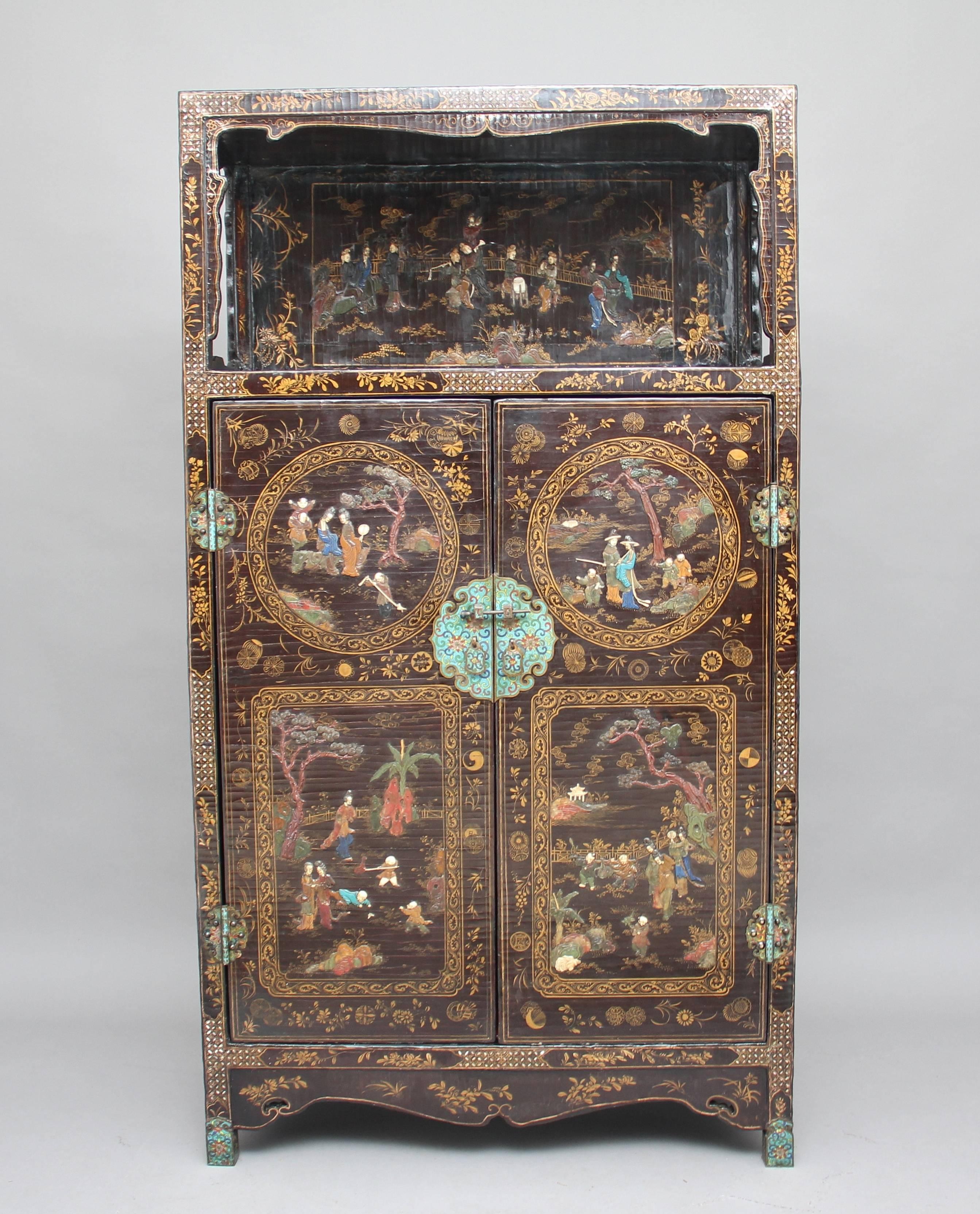 A superb quality early 19th century Chinese black lacquered hardstone inlaid cabinet in fantastic condition, profusely decorated all over this really is a magnificent piece, having an open top with a shaped frieze, the back having floral gilt