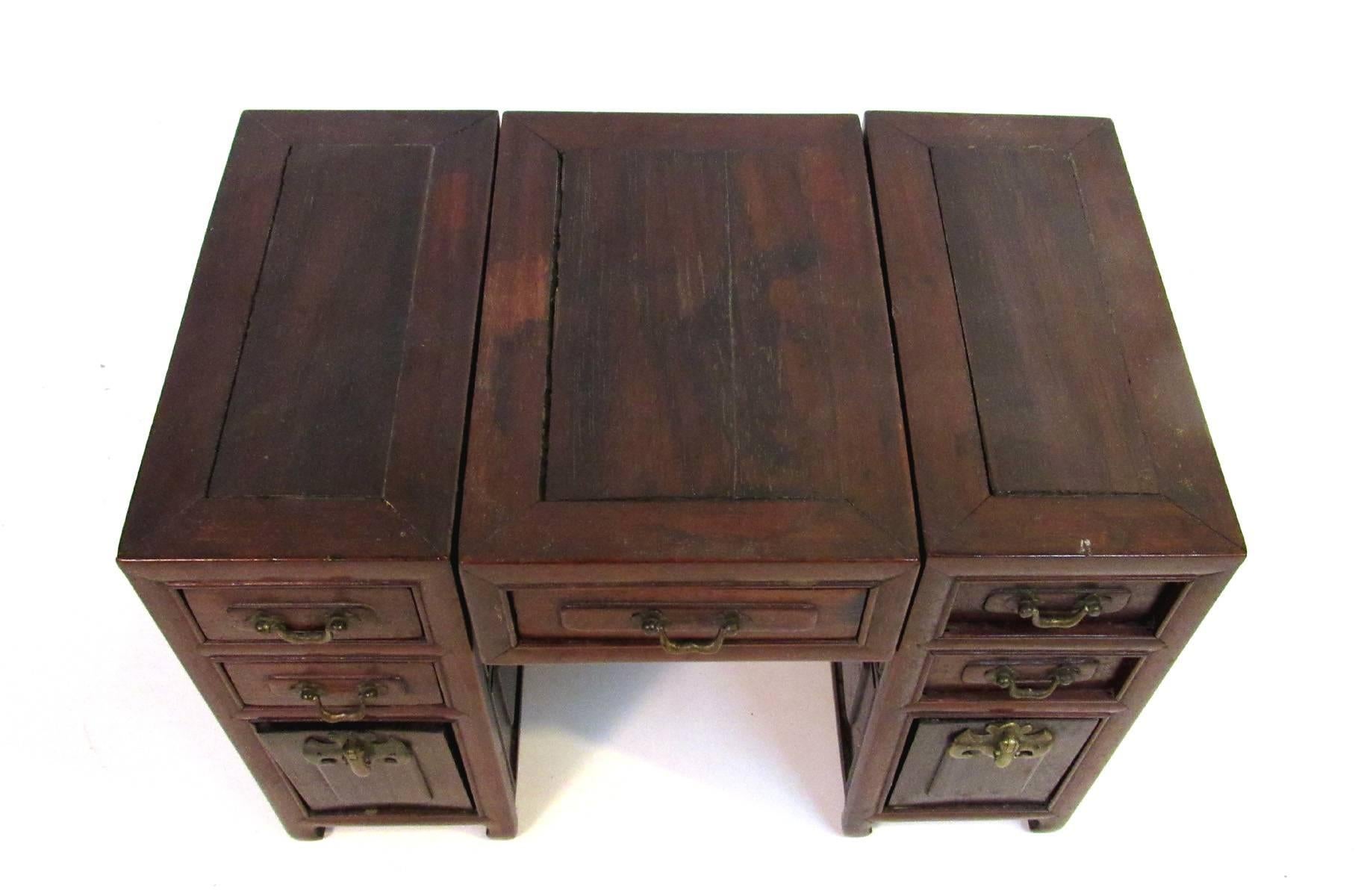 Early 19th Century hand-made miniature desk made from blackwood, in three sections, each pedestal with two drawers and a lift out panel, center section with single drawer, all drawers with brass handles, the panels with bat form locks. Extremely