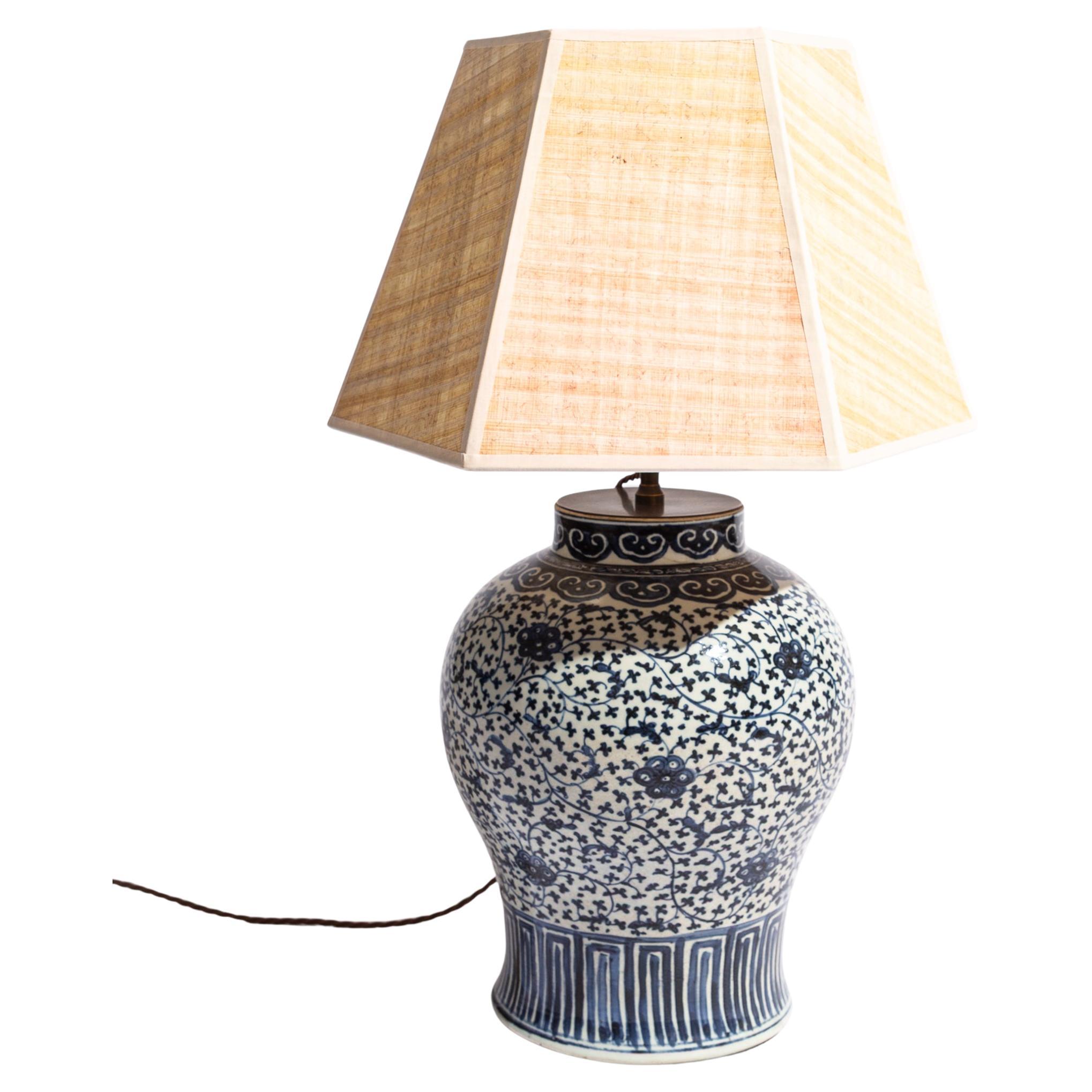 Jarra de porcelana china azul y blanca de gran calidad de principios del siglo XIX, convertida en lámpara.

De forma de balaustre decorado con volutas de loto continuas bajo una banda de ruyi en el cuello.

Se muestra aquí con una pantalla Papyrus