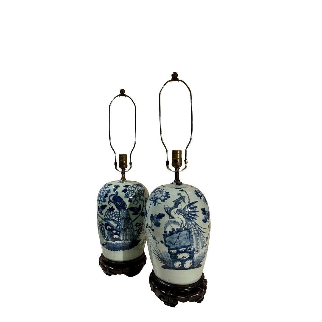 A pair of early 19th century porcelain vases as lamps with flowers and phoenix birds. The stands are rosewood and finials are brass balls. The lamps vary in color which is normal.