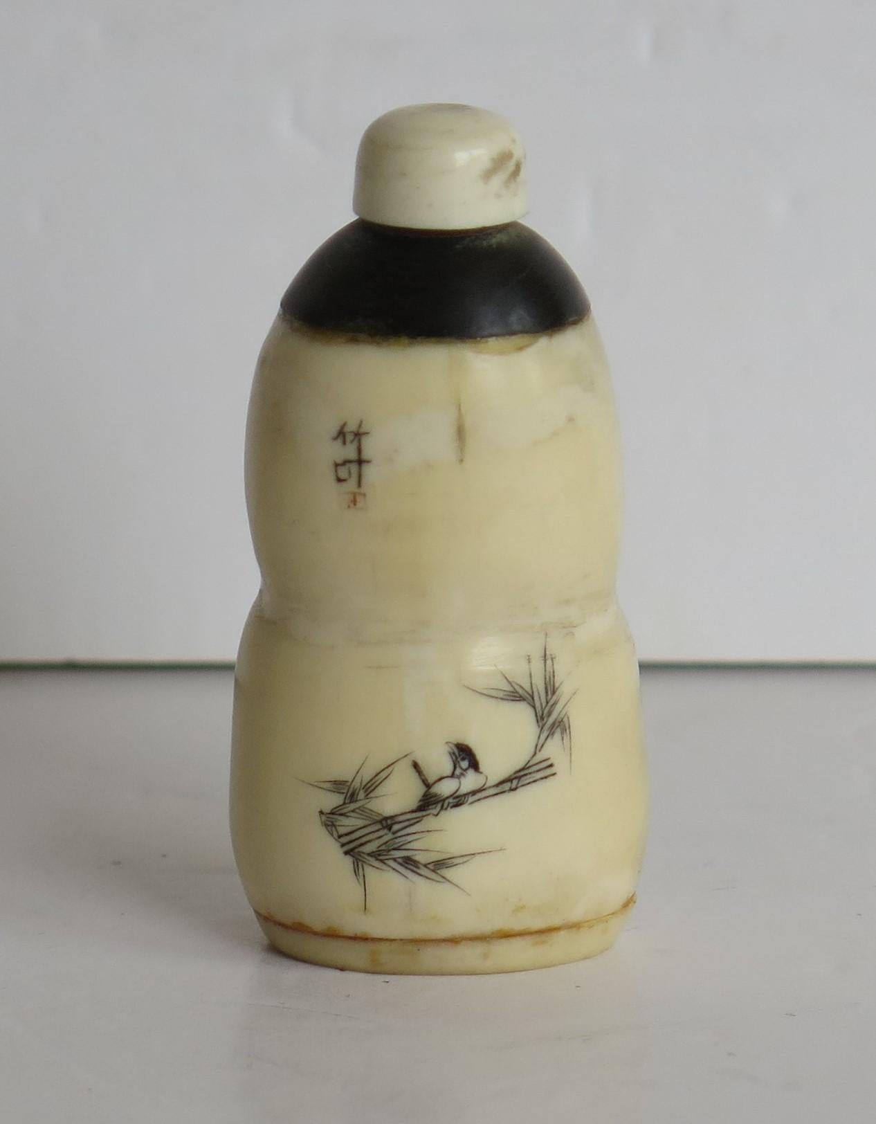 This is a very good Chinese hand carved, Bone Snuff Bottle with an engraved and inked bird decoration, which we date to the early 19th Century, circa 1830. 

The bottle is made of composite bovine bone, hand carved in a gourd shape, with a dome