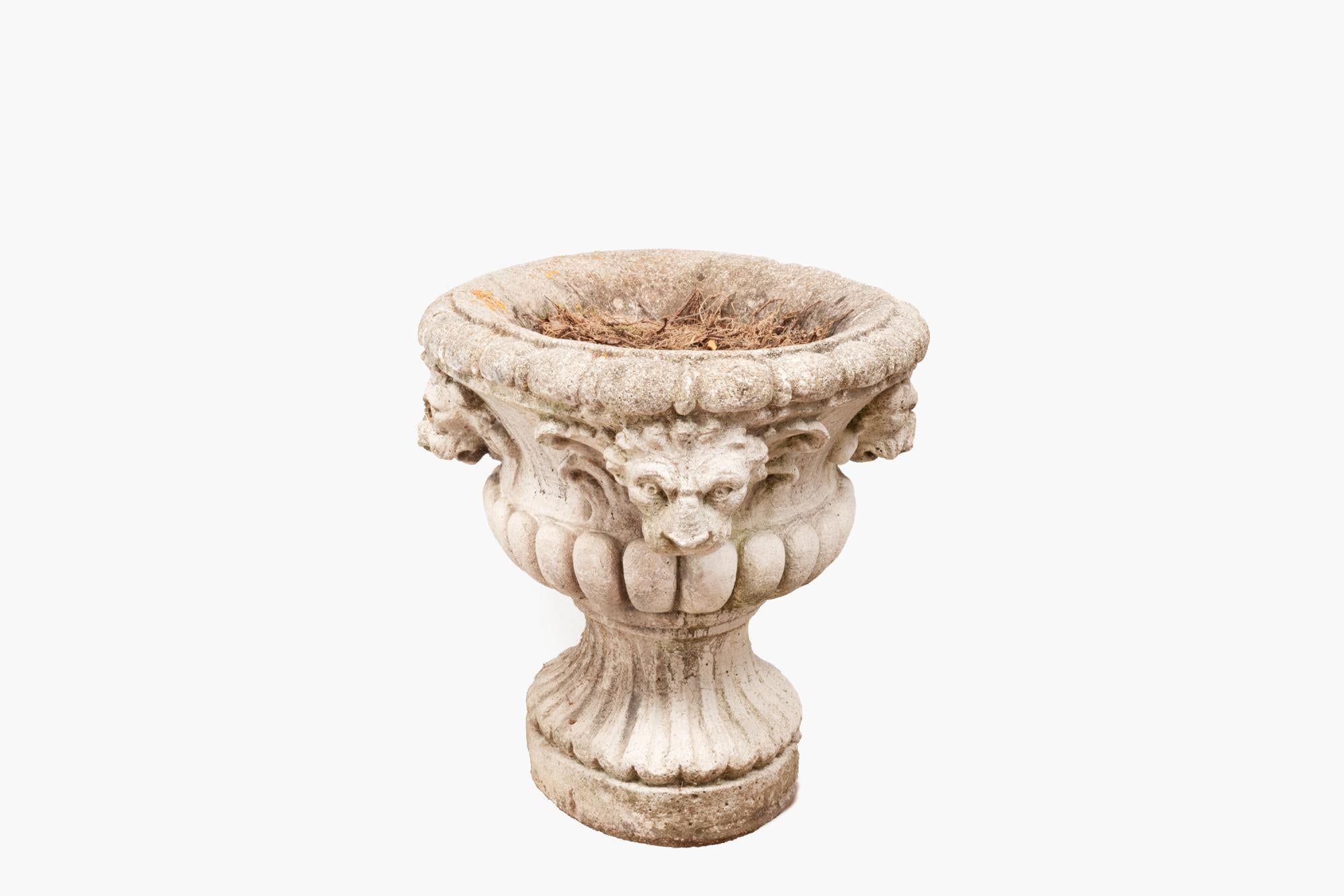 Early 19th Century Portland stone classical style oval shaped urn with carved lion mask detailing sitting on a fluted base.
