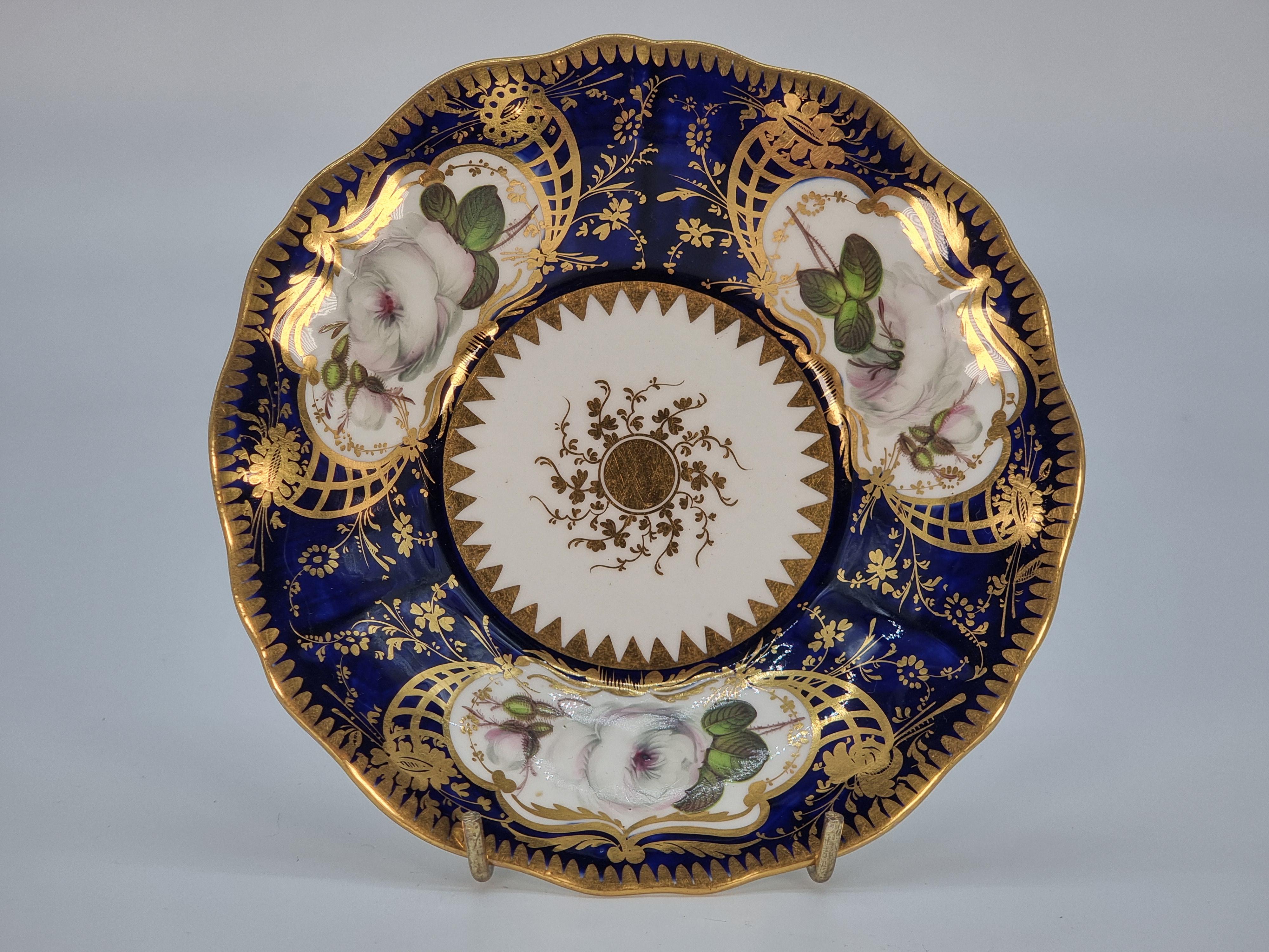 Cet ensemble se compose d'une soucoupe, d'une tasse à thé et d'une tasse à café. Toutes les pièces sont richement peintes à la main sur un fond bleu royal foncé. Trois panneaux sur chaque pièce sont magnifiquement peints à la main avec des roses