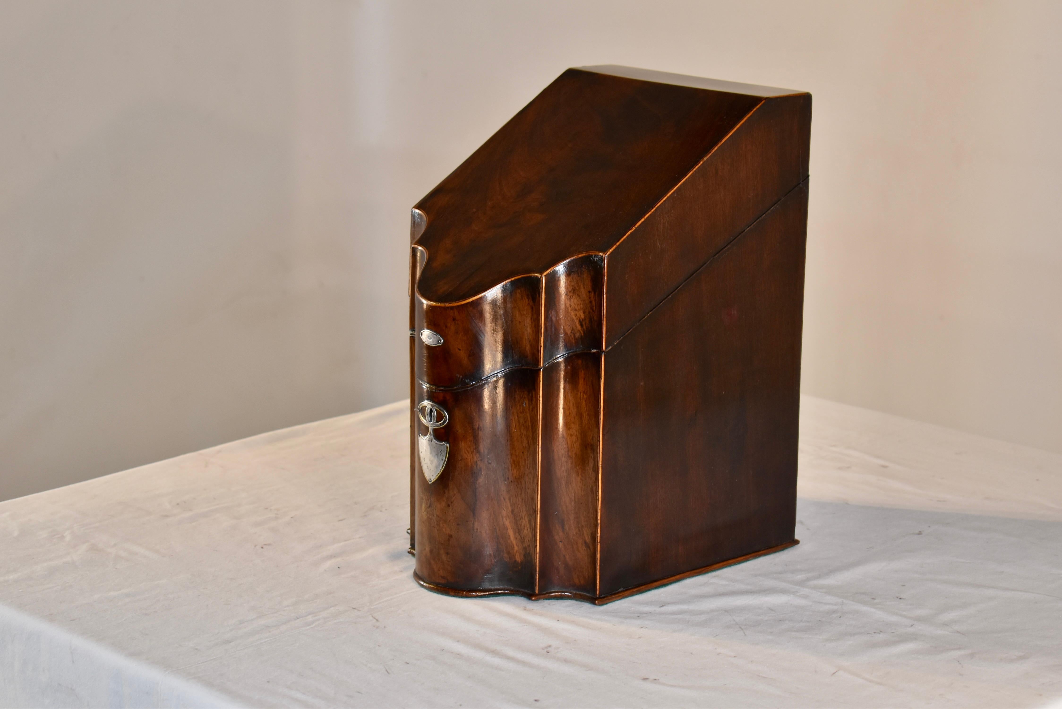 Early 19th century stationery box, which has been converted from a knife box.    It is a classic serpentine shape in the front, with the edges inlaid in boxwood.  There is a central silver plaque on the top lid of the box and a silver escutcheon on