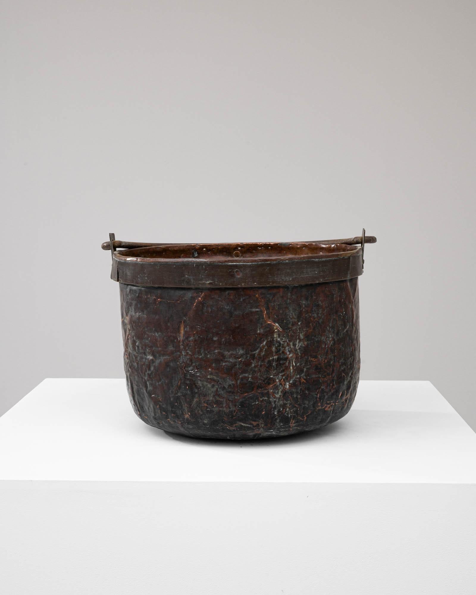 Step back in time with this authentic Early 19th Century Copper Bucket, a testament to enduring craftsmanship and vintage charm. Each inch of its weathered surface tells a story of years gone by, from the rich patina on the copper banding to the