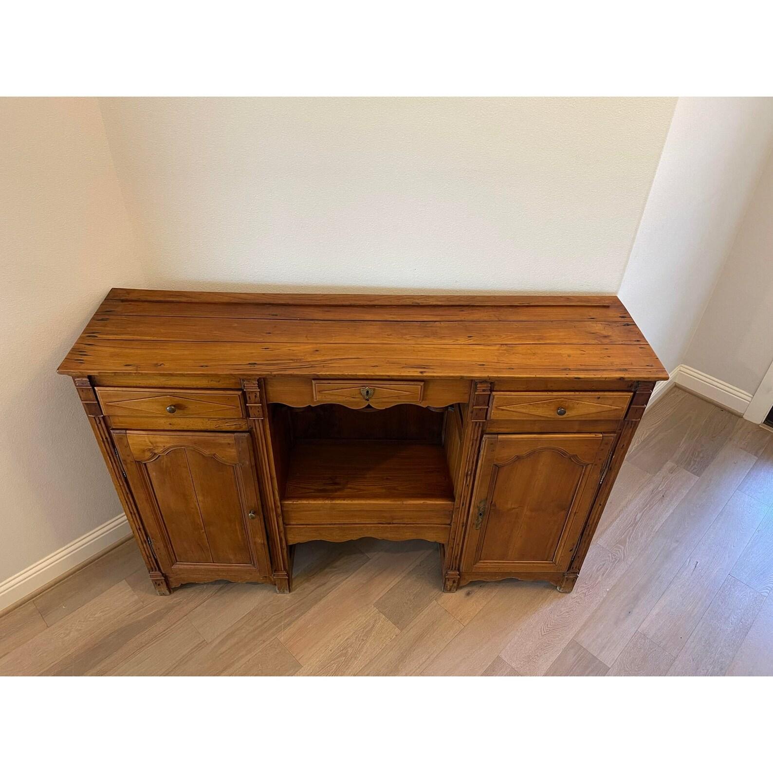 Southwestern France, circa 1820, Provincial Picardie influences, having a rectangular three board planked top, over a trio of frieze drawers, featuring central open shelf wine bottle storage designed to display large vineyard winery magnum bottles,