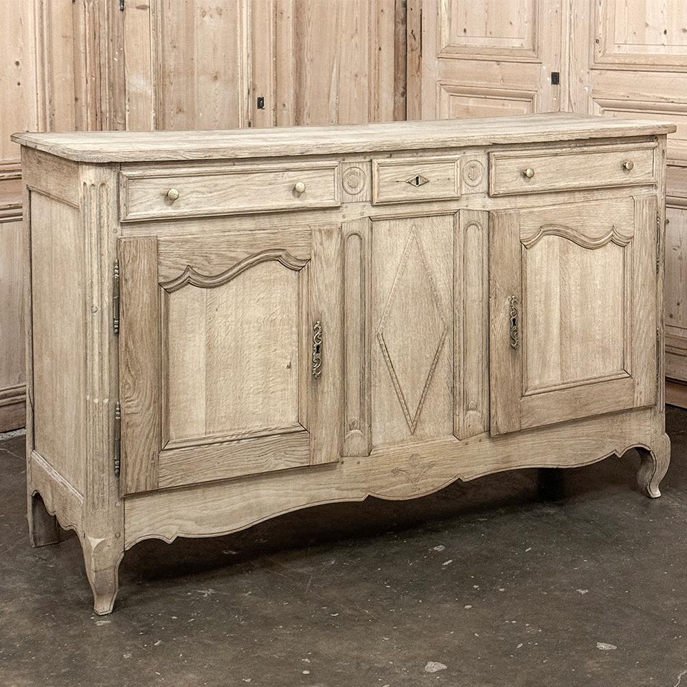Early 19th Century Country French Buffet in Stripped Oak is truly a classic that will never go out of style!  Hand-crafted from select old-growth oak, it features a thick plank top with a cove bevel around the edge, which overlooks the top tier of