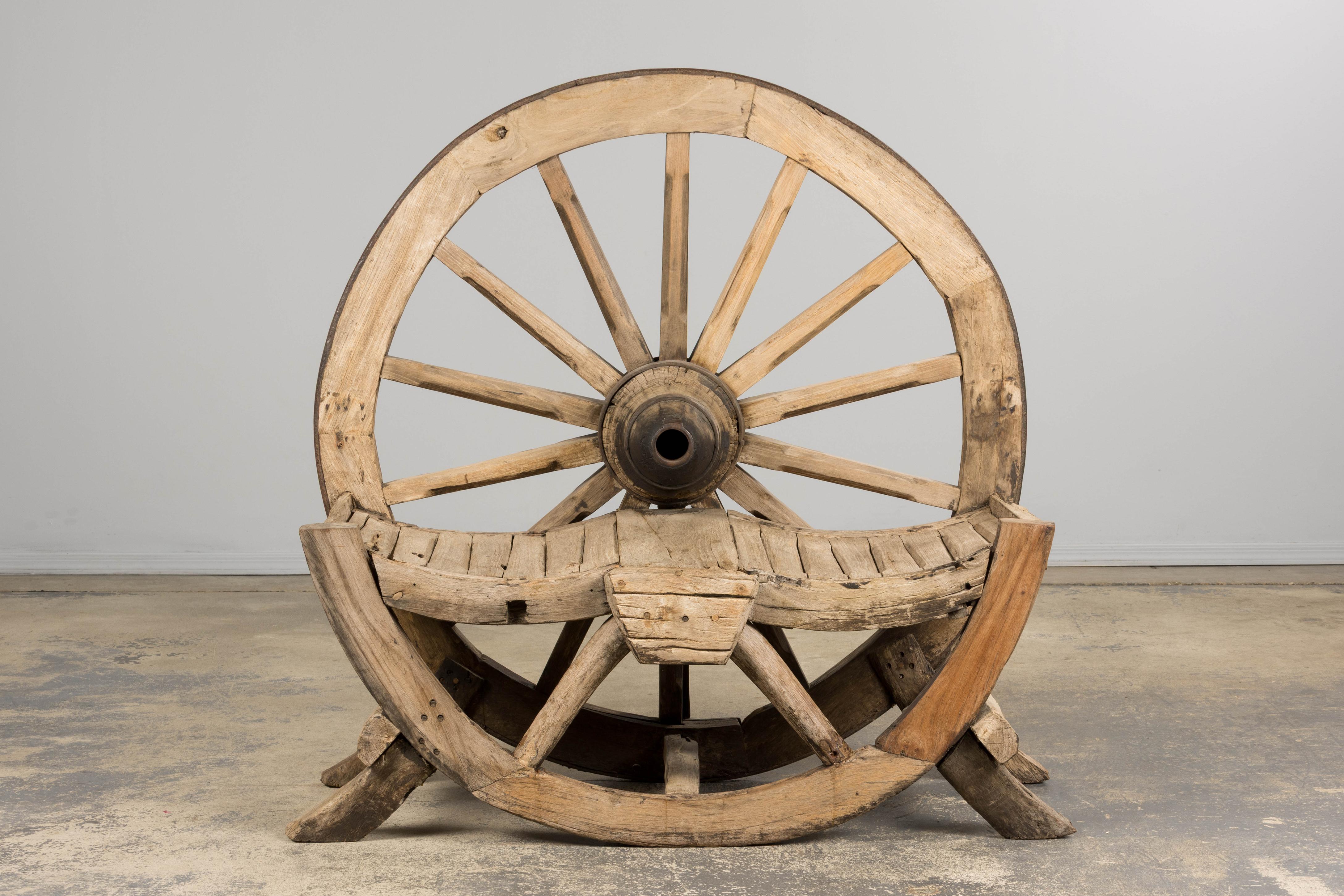 Un banc monumental et unique en son genre, provenant de Provence et datant du début du 19e siècle. Cette pièce extraordinaire, qui était à l'origine une roue de chariot fonctionnelle, a été transformée avec soin en un banc de jardin sculptural, une