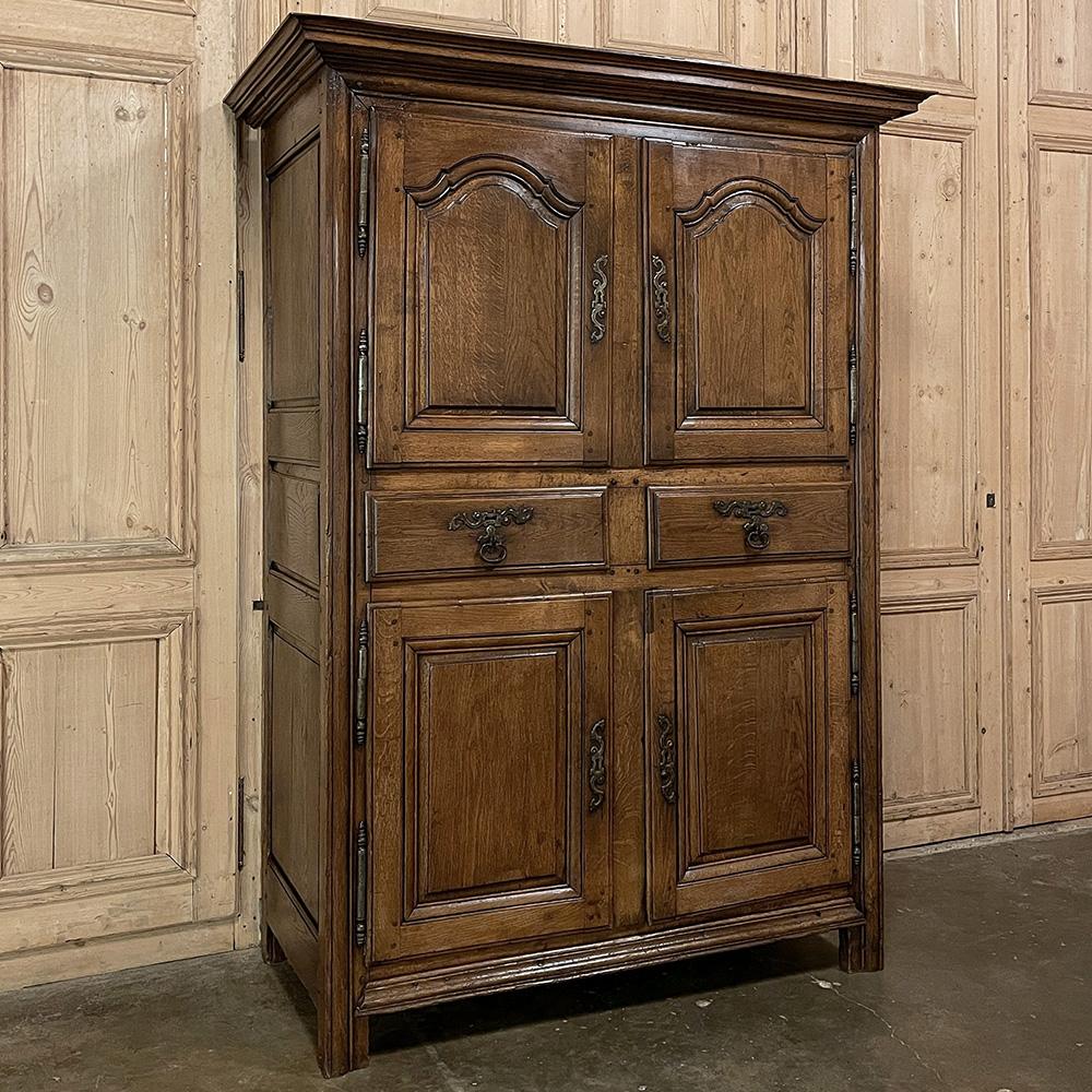 Early 19th century country French four door wardrobe was designed to be a versatile storage piece perfect for the casual or rustic decor! Hand-crafted from dense, old-growth oak, it was assembled using pegged mortise & tenon joinery in the technique