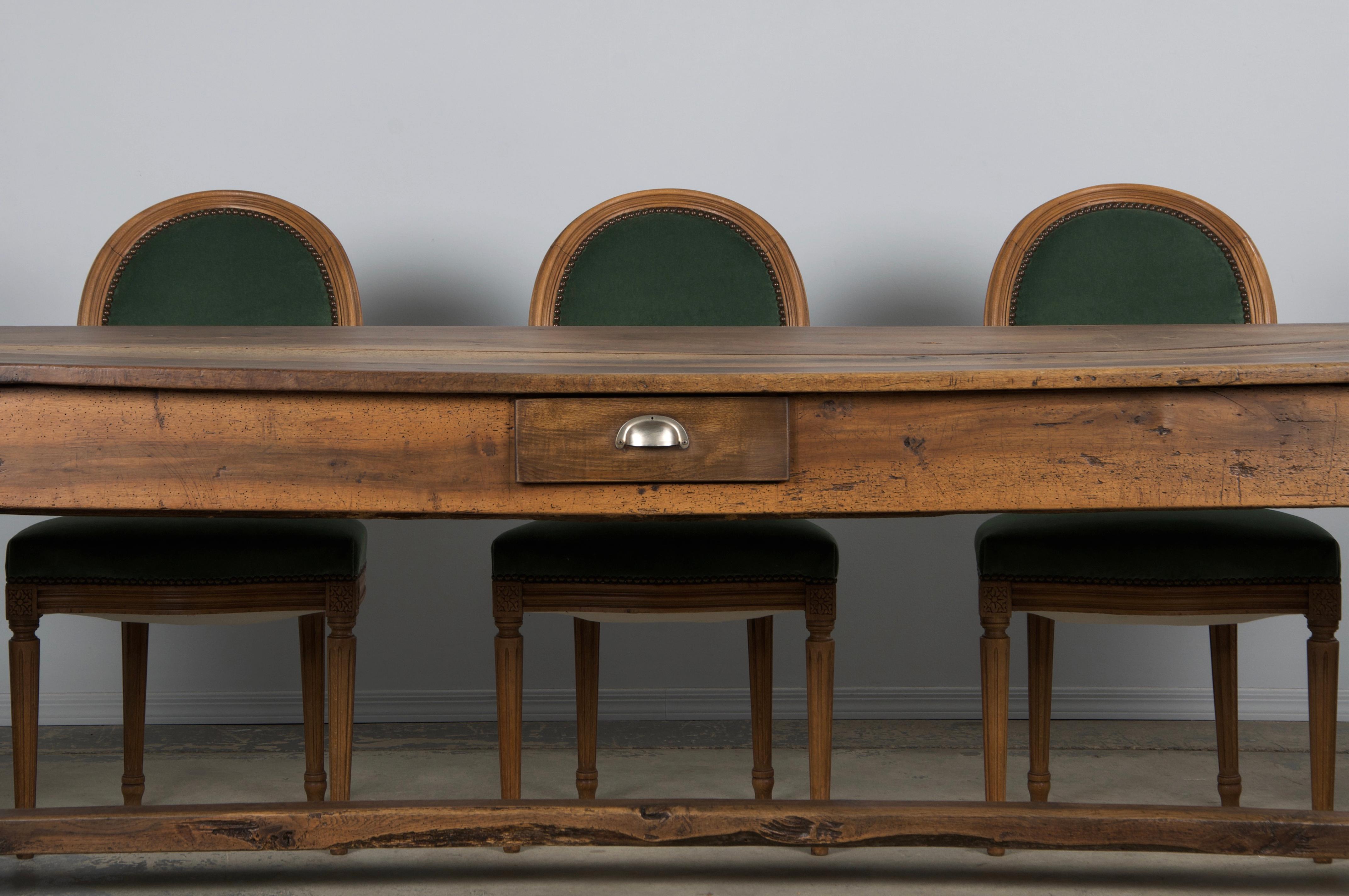 An early 19th-century Country French farmhouse trestle dining table, perfect for a kitchen or as a large console, sourced from Provence, France. Beautifully handcrafted from solid walnut, it features an 8'3