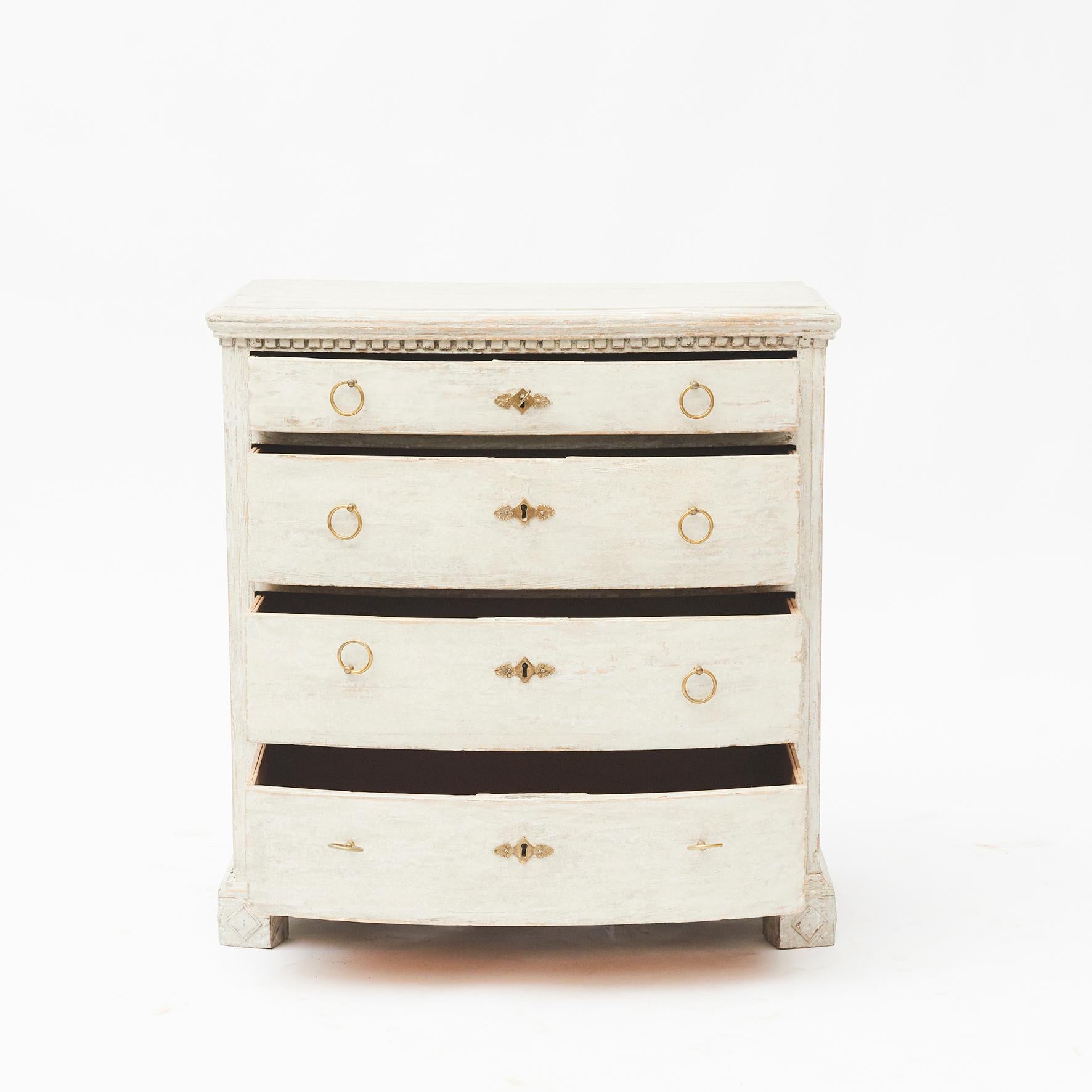 Danish Empire chest of drawers.
Four drawers with bowed front, top with dental molding.
Resting on legs adorned with diamond motifs. Light grey painted.
Denmark, circa 1810.