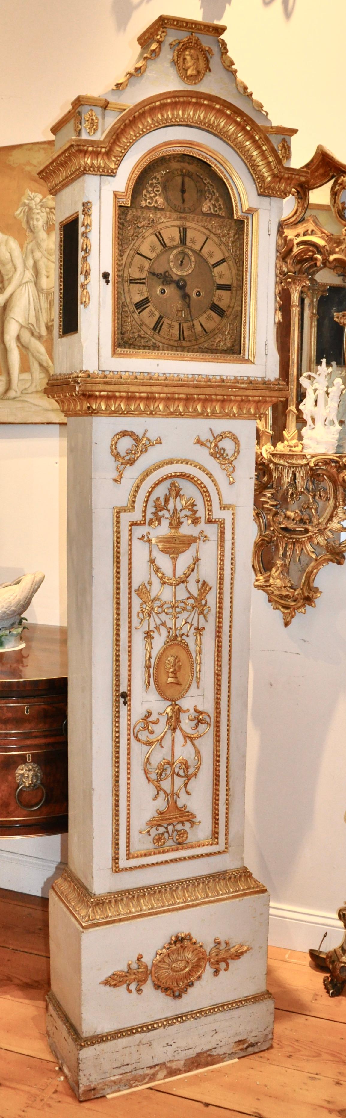 Early 19th century Danish carved and giltwood neoclassical tall case clock. Original gilding on all hand carved neoclassical ornamentation. Palace provenance, more than likely. Profile of each a man and a woman, most likely nobility or from the