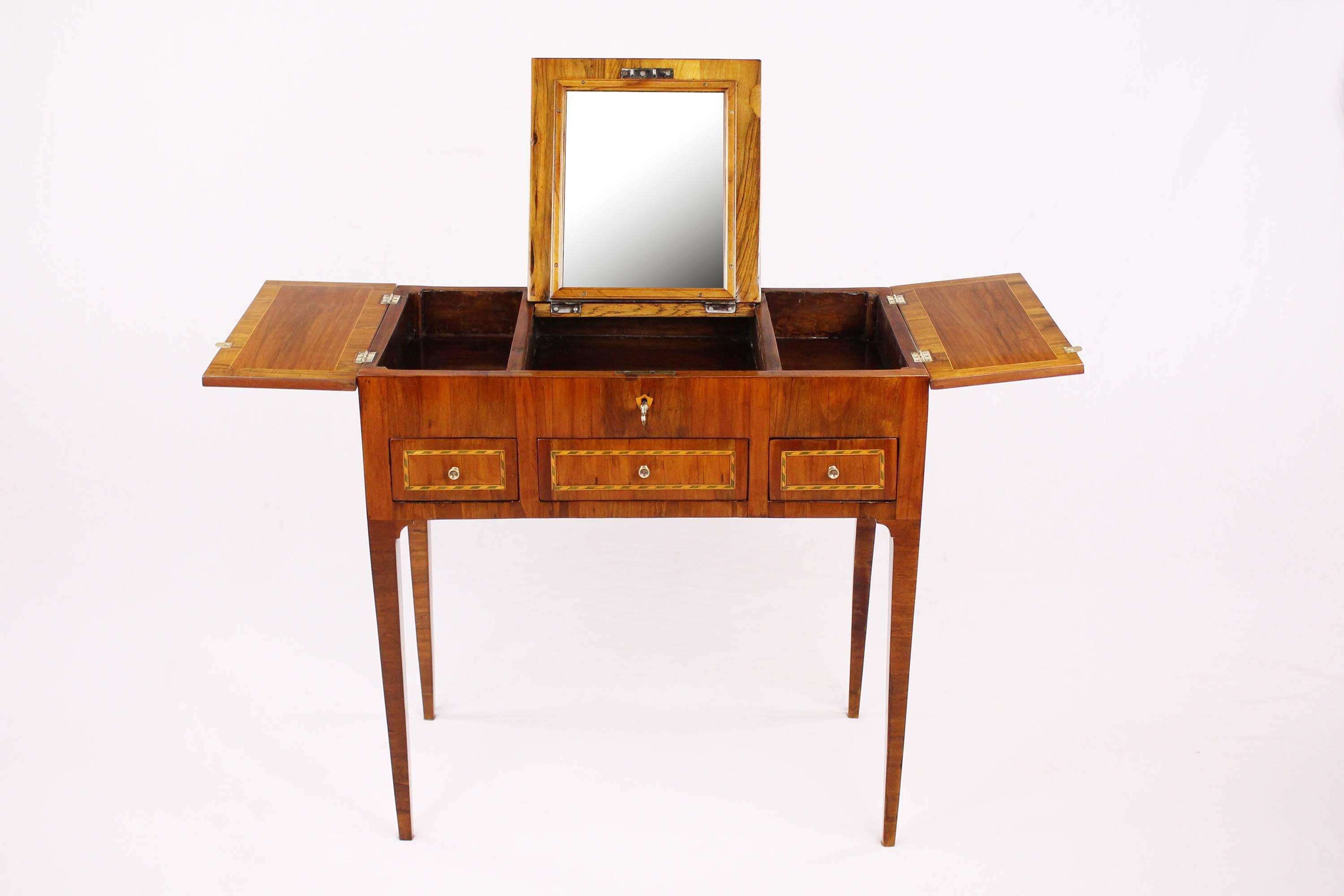 • Early and very rare 19th century dressing table in beautiful condition
• Poudreuse
• Mahogany veneered
• France, circa 1810-1820
• Beautiful marquetry works
• Three small pushes, on top openable, middle field with puttable up mirror
•