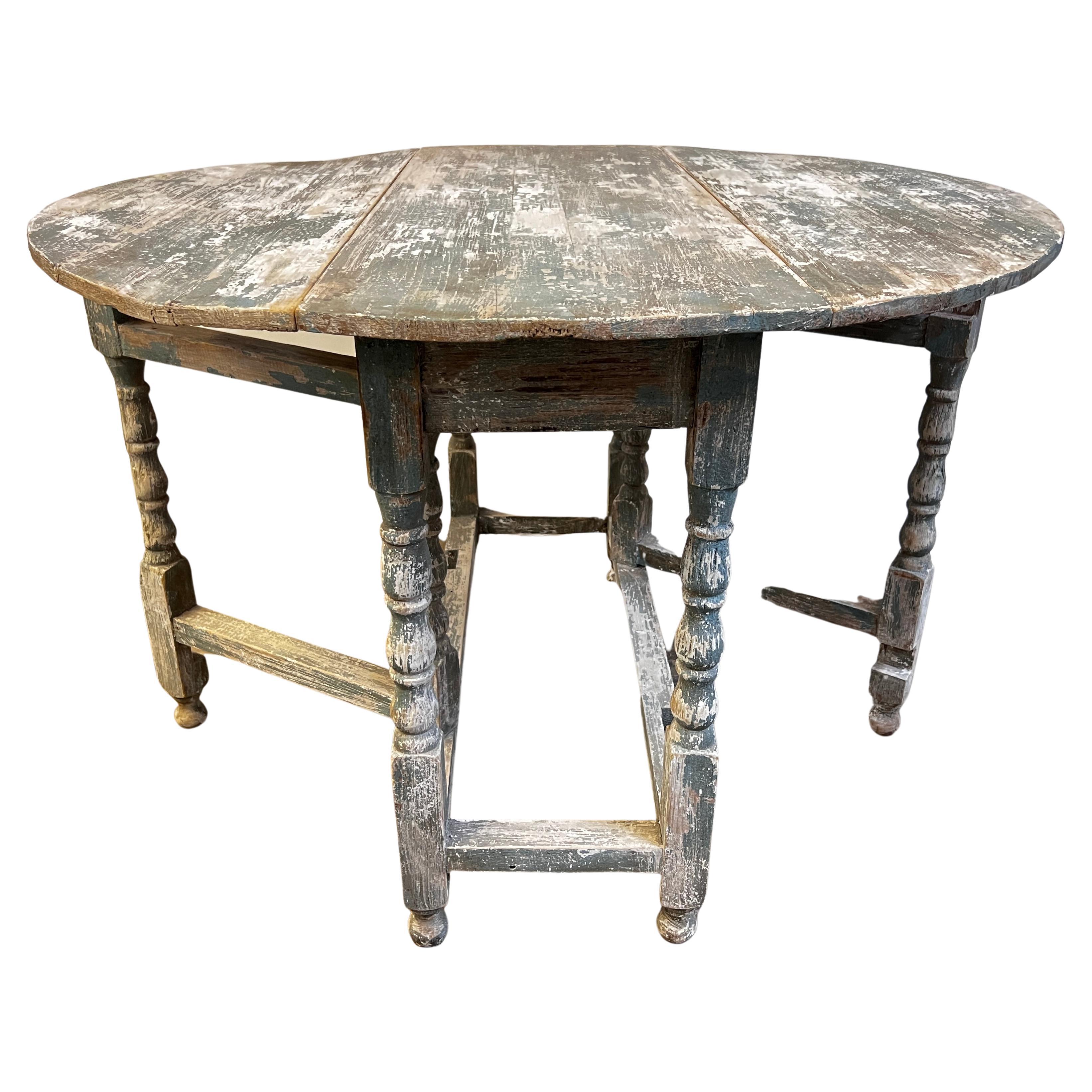 Here is a beautiful early 19th century Swedish Gustavian drop leaf table with a gate leg. Dry scrapped with beautiful and unique colors to this one. This piece is best used as a console as the drop leafs and swing legs are fragile. This has been
