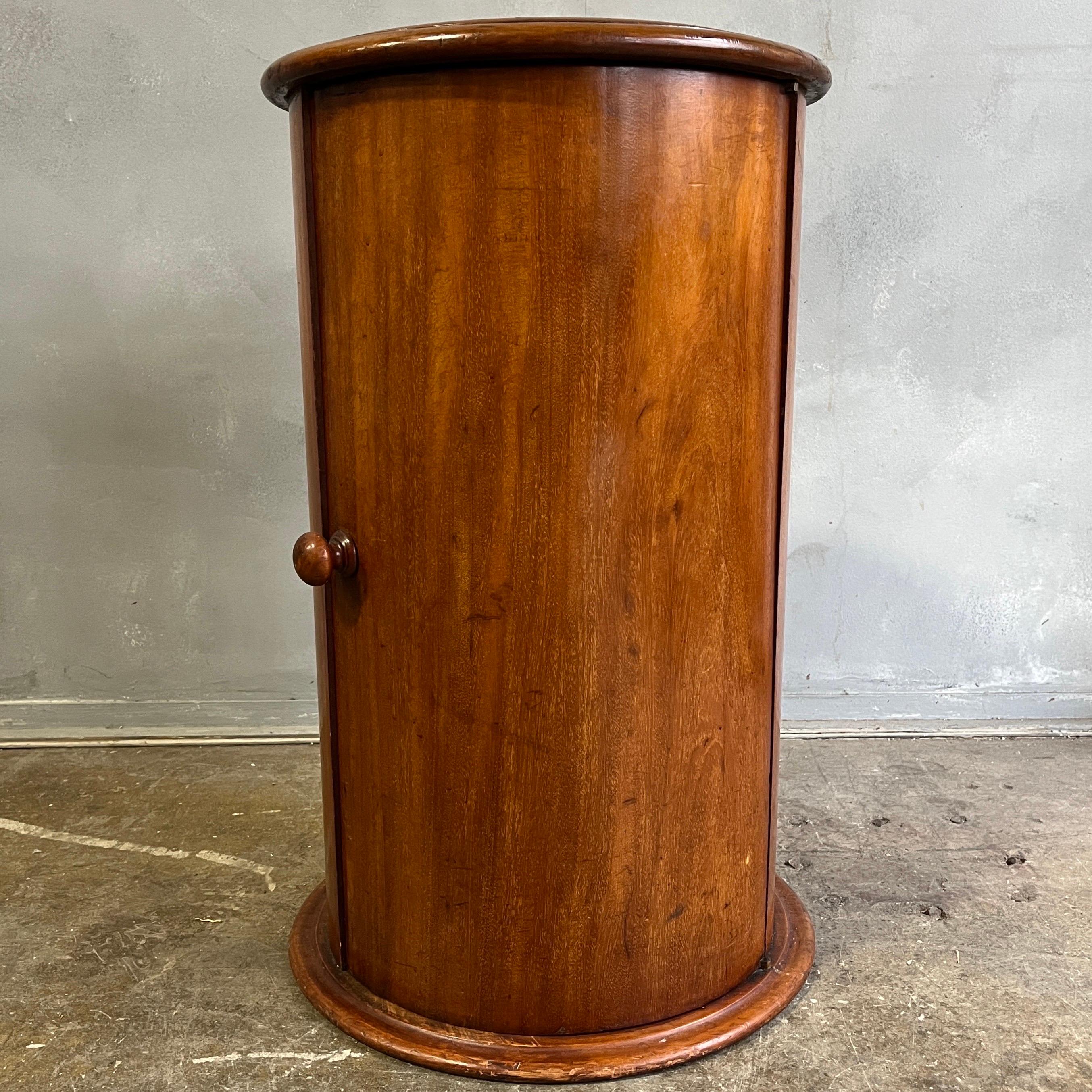 French, 19th century veneered wood somneau, somno, or drum table having a circular top inset with white marble above a conforming cylindrical body with single door opening to a shelved interior on circular plinth base. beautiful original patina.