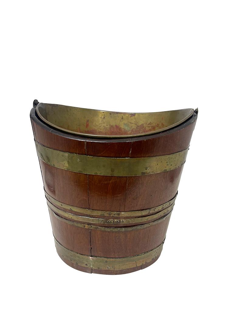 Early 19th Century Dutch brass bound tea kettle bucket

a Dutch early 19th century tea kettle heater. This tea kettle bucket is made of wood in vertical strips bound with copper bands and these are nailed. Inside the bucket is a copper lining, this
