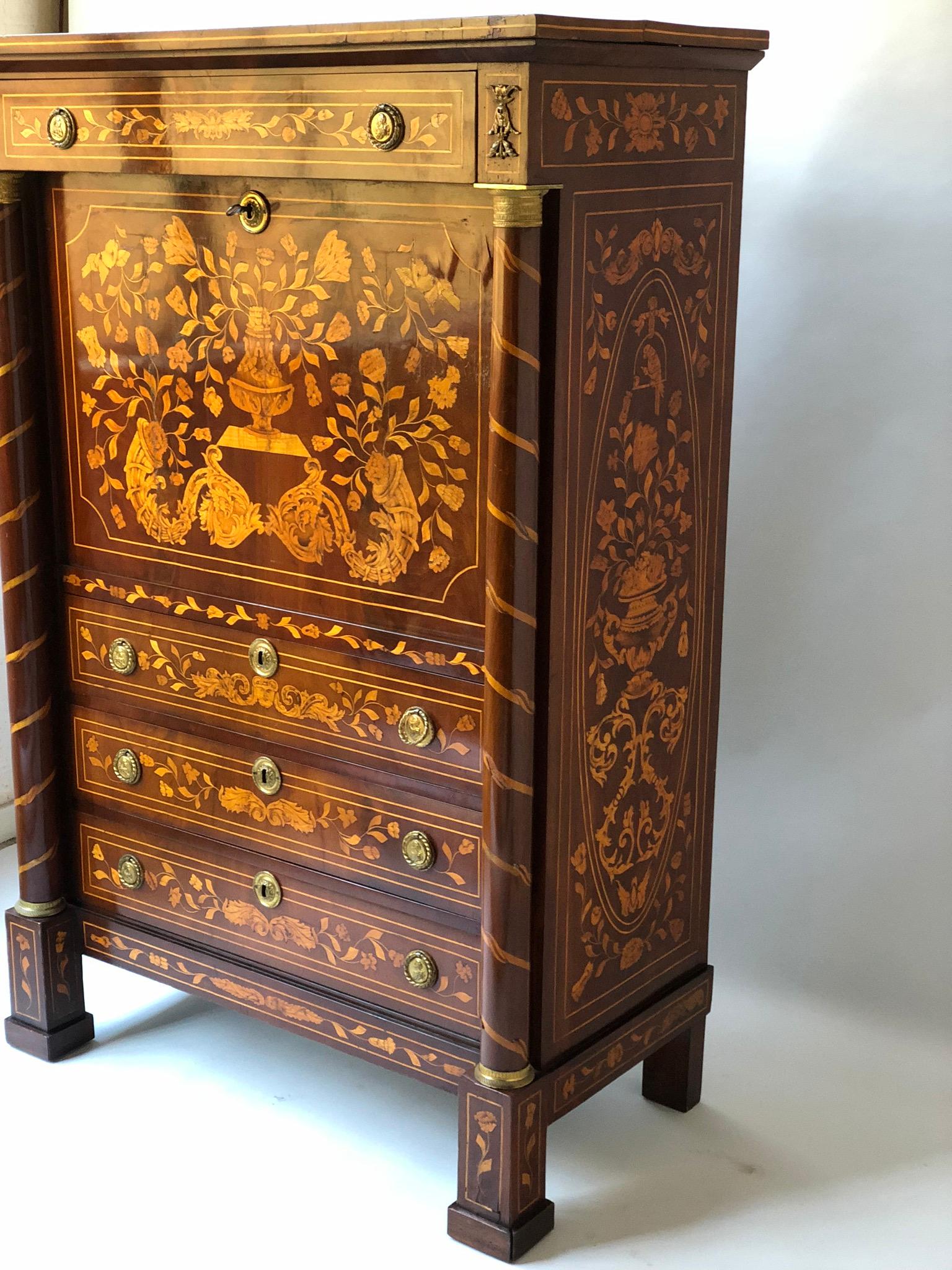 An early 19th century Dutch mahogany and satinwood foliate marquetry secretaire a abattant with fall front enclosing a well fitted interior of short drawers and gilt tooled green leather writing surface(which holds solidly at the horizontal and