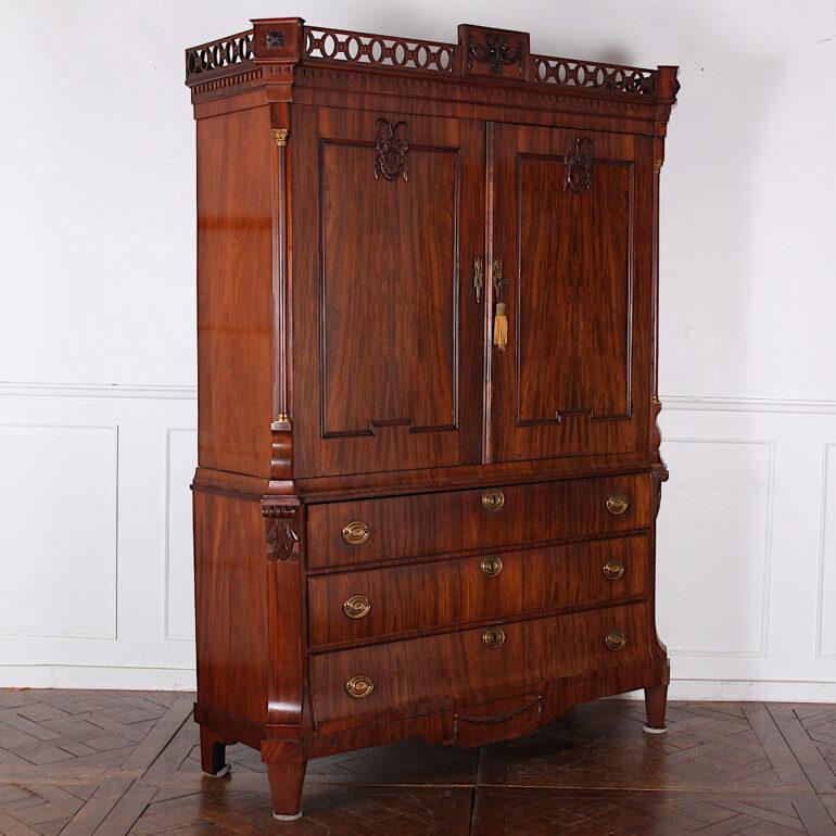 Early 19th century Dutch mahogany linen press, the figured mahogany doors opening to a shelf and smaller fitted drawers, and with three large graduated drawers to the base. Raised on square tapering legs below canted corners with columns and gilt