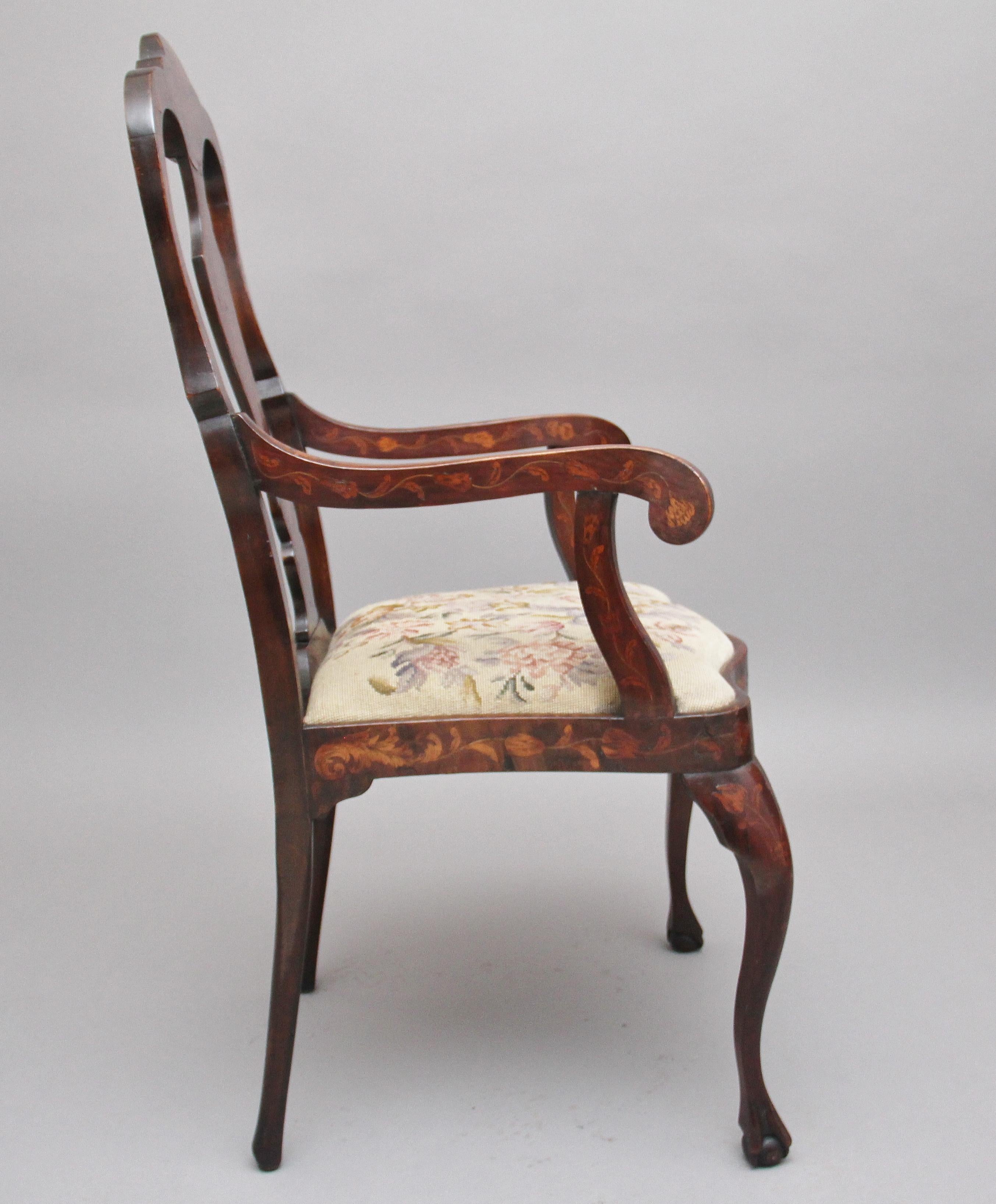 Early 19th century mahogany Dutch marquetry armchair, having an arched crest rail and vase shaped splat, elegant shaped arms and supports, drop in upholstered seat with a needlework floral pattern, standing on cabriole legs terminating on ball and