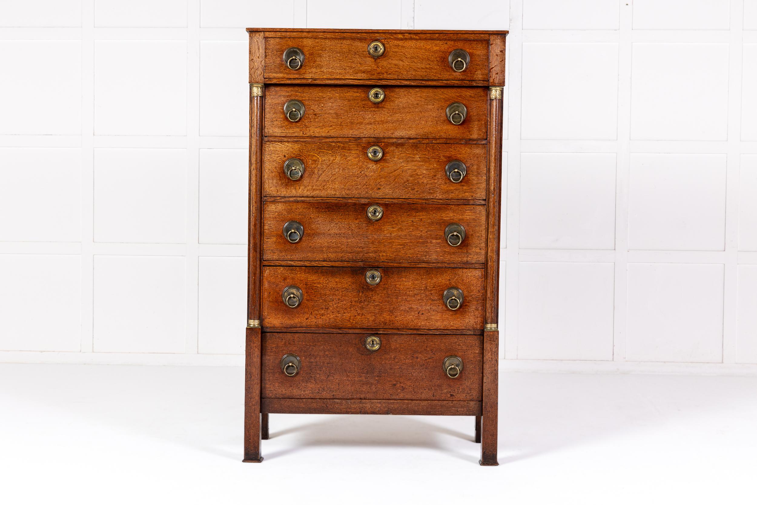 Interessante cassettiera alta in Oak olandese dei primi del XIX secolo.

Con la forma di un semainiere francese ma con sei cassetti anziché i soliti sette, si ispira ai mobili dell'Impero francese con le sue colonne ai lati con capitelli in ormolu.