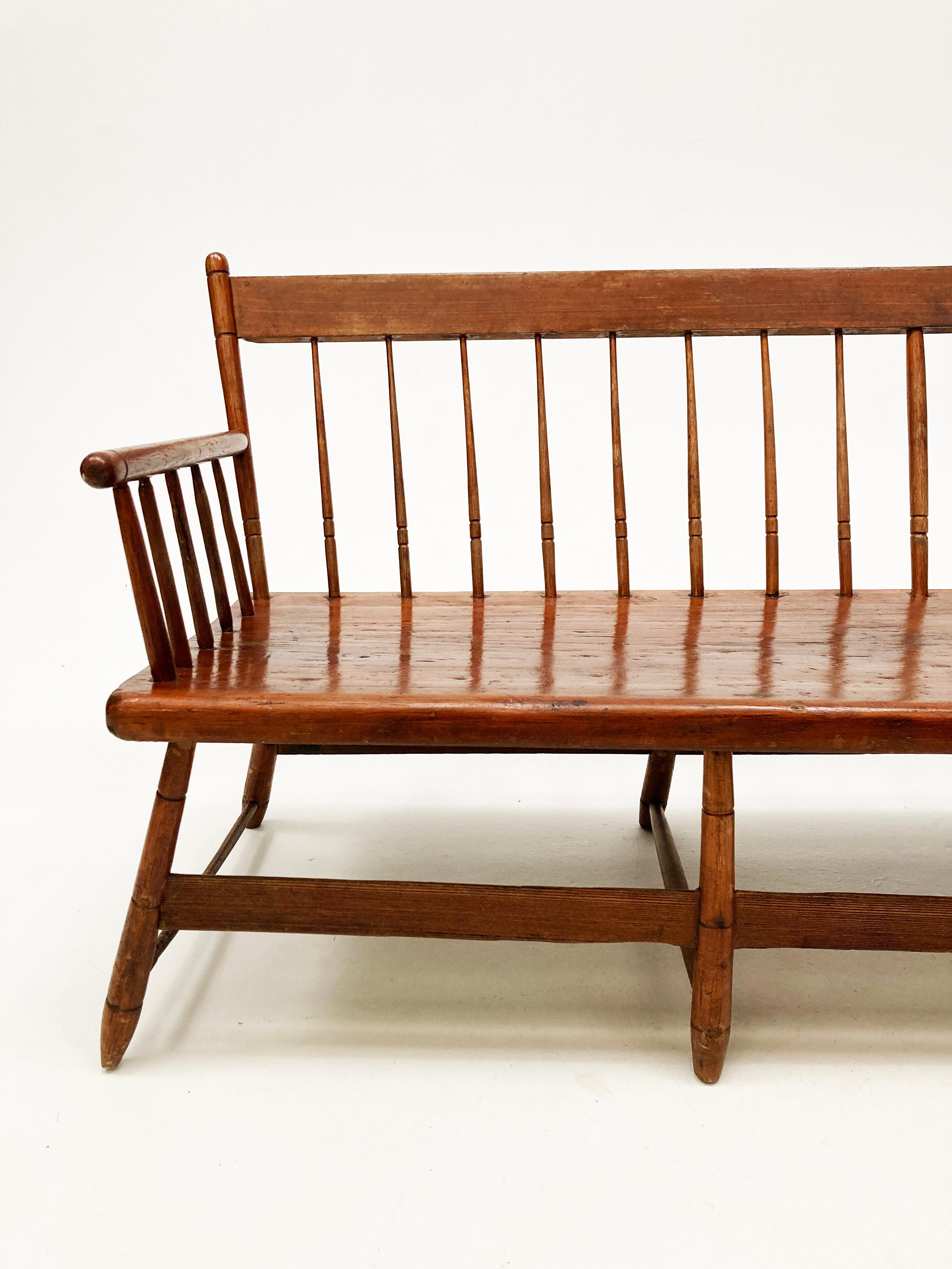 This Early American Windsor Spindle-back Meeting House Bench is made from very old hand hewn pine planks and is an amazing antique work of artisanship from this early era. Primitively made, this meeting house bench would have seen many town