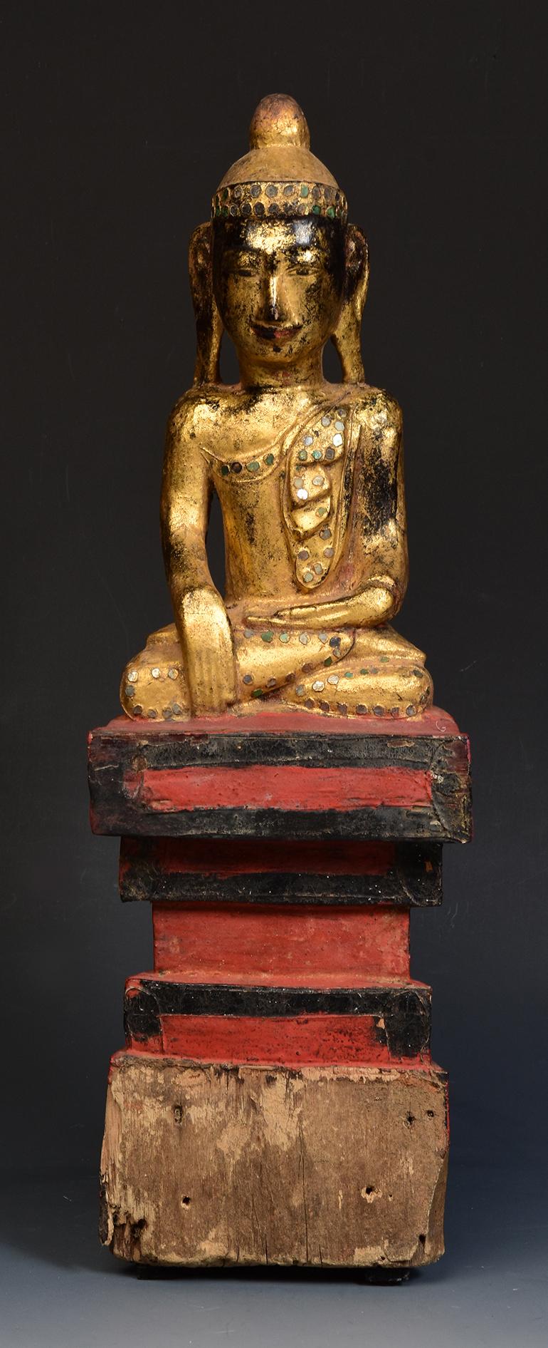 Burmese wooden Buddha sitting in Mara Vijaya (calling the earth to witness) posture on a base, with gilded gold and glass.

Age: Burma, Early Mandalay Period, Early 19th century.
Size: Height 41.3 cm. / width 13.3 cm.
Condition: Nice condition