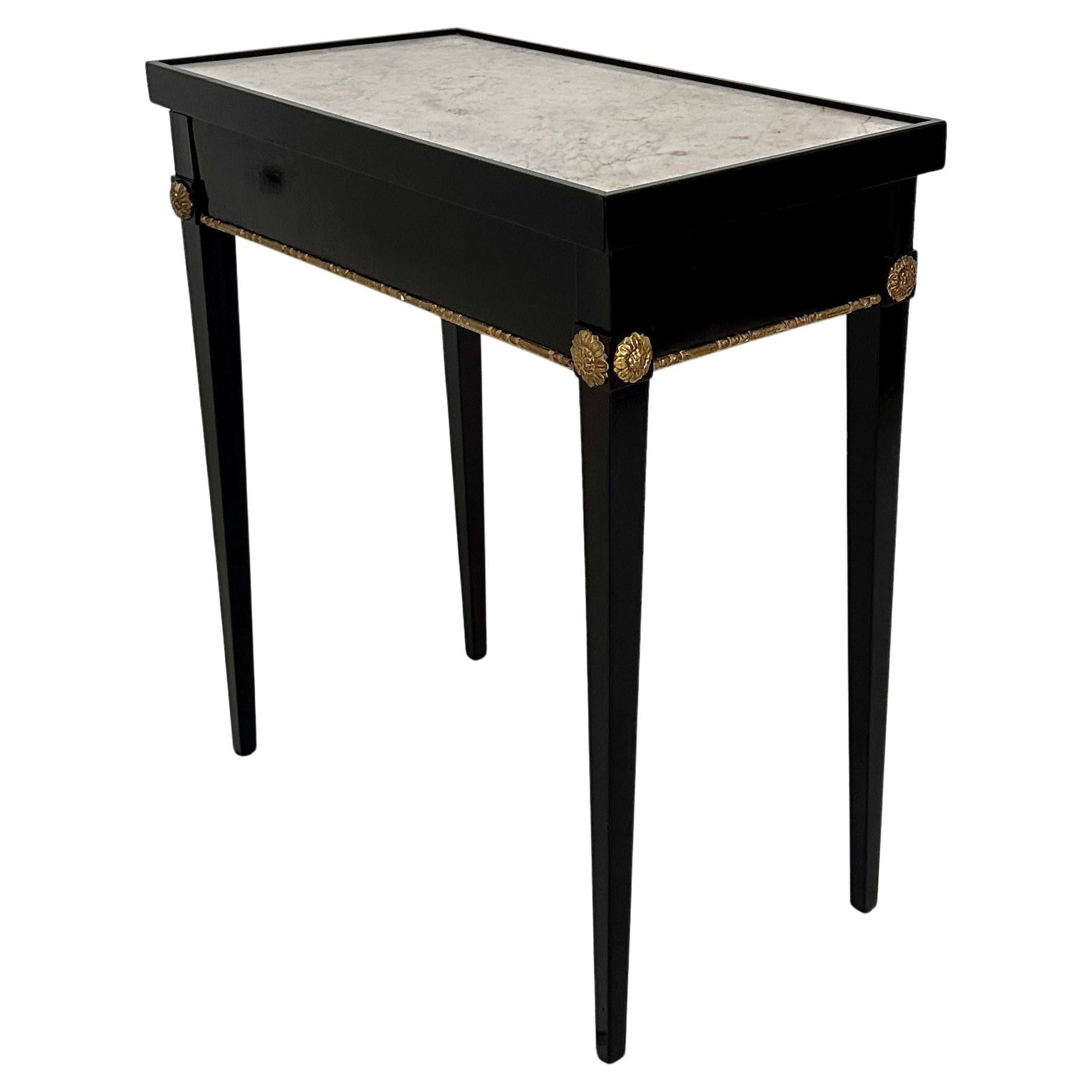 This striking console table, crafted in France circa 1808, embodies the grandeur of the Empire style. Its ebonized wood frame, finished to a deep, lustrous black, provides a dramatic contrast to the pristine white marble top. The table's design is