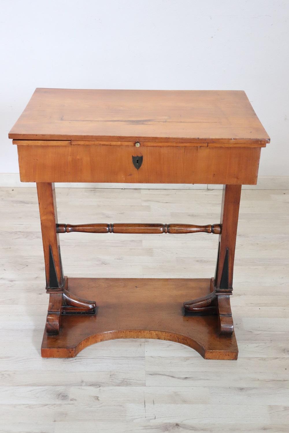 Lovely italian of the period Empire side table in cherry wood. This rare side table turns into a delightful little desk hidden inside the drawer. Internally equipped with numerous small compartments on the sides and under the writing surface. The