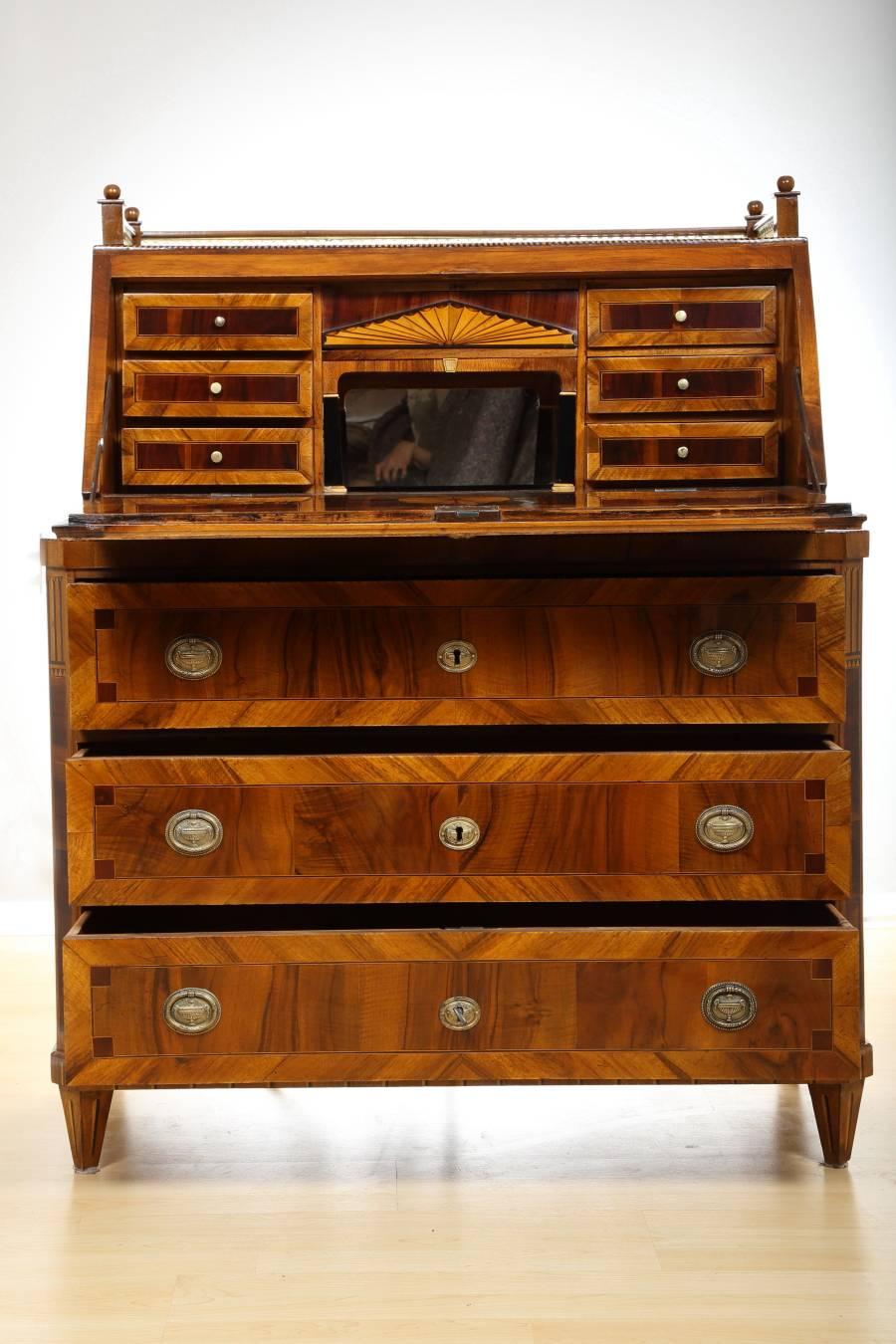 Early 19th century Empire fall-front secretaire in walnut, circa 1810. This unique piece has six small drawers, three large drawers, and additional compartment doubling as a safe. The secretaire also features a mirror and inlay board. It has been