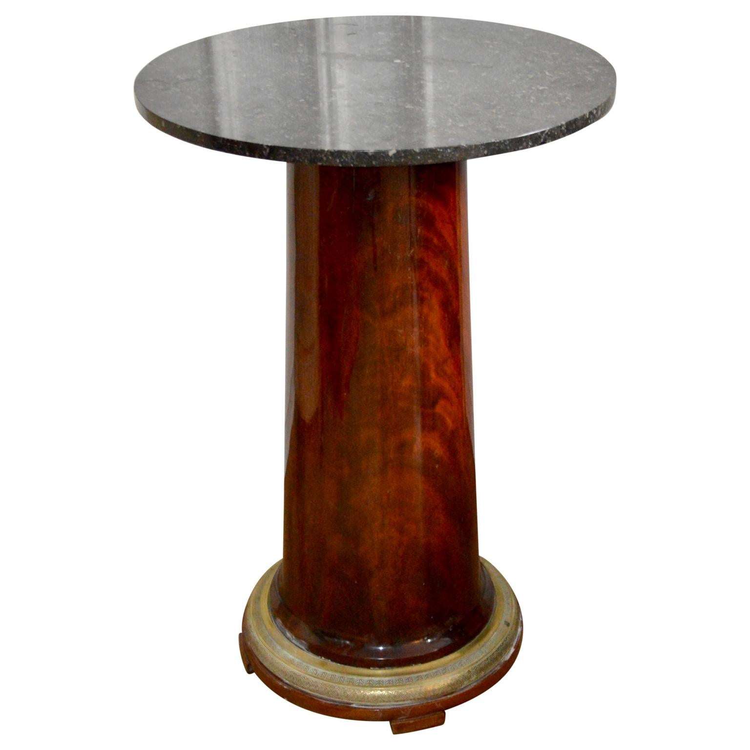 Empire period marble topped gueridon with a flamed mahogany base, finished with a lustrous French polish. The foot have a finely cast brass ring for decoration.