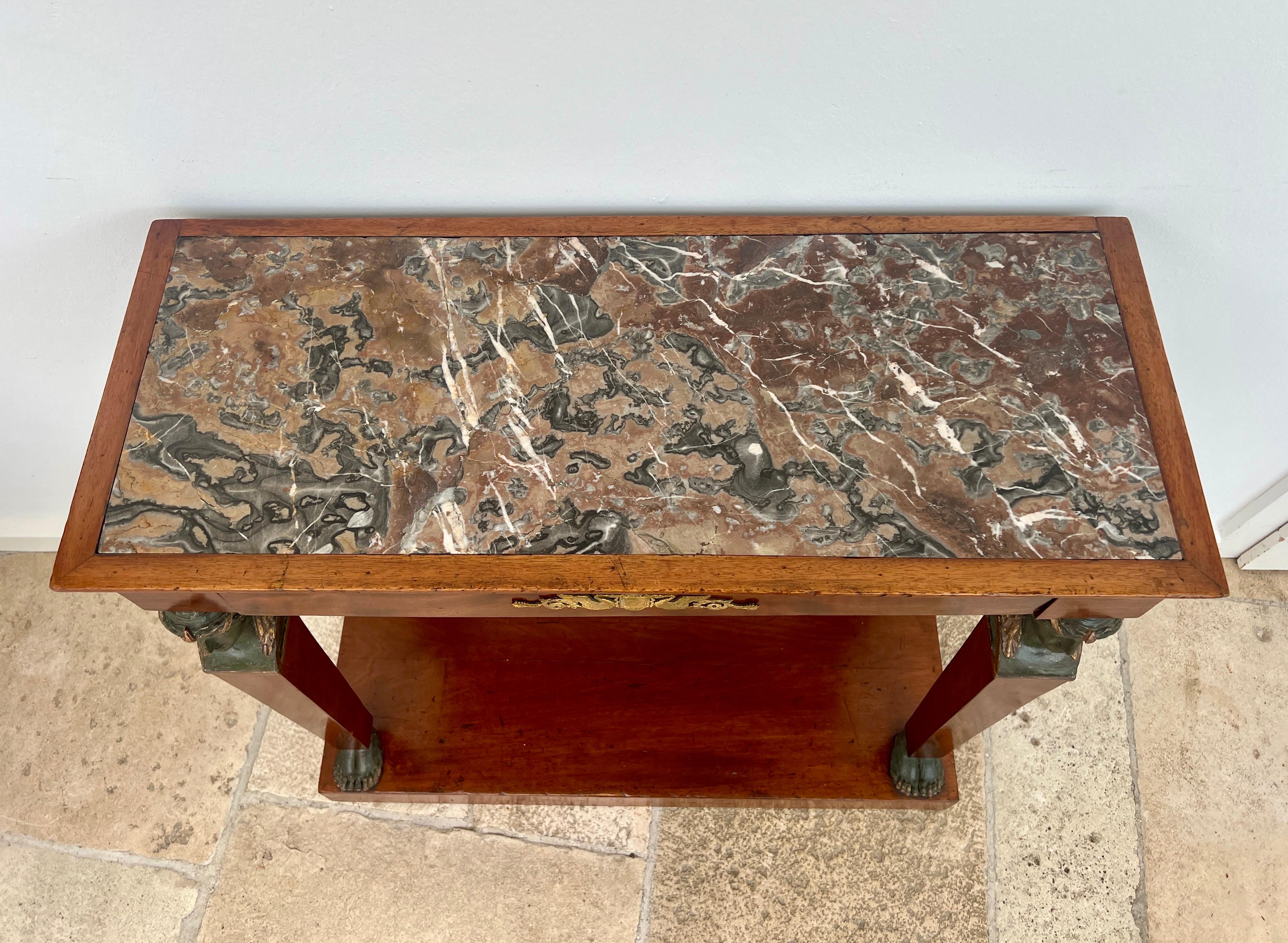 This finely crafted console table impresses with its strict architectural form and a striking, rare marble top. The frieze houses a large drawer (without lock), subtly integrated into the design. Beautiful historic patina enhances the rich mahogany