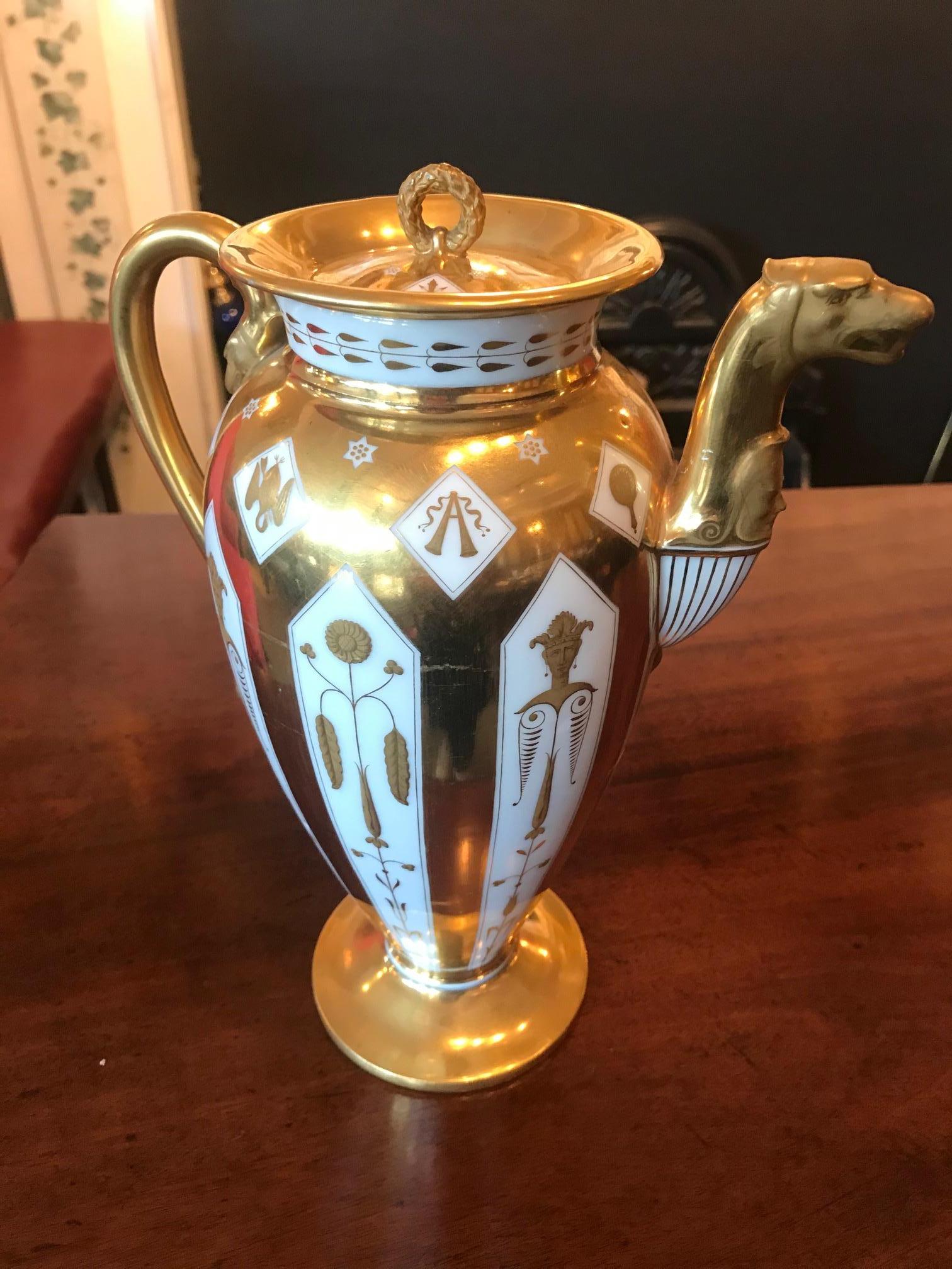 Early 19th century Empire Nast Paris porcelain coffee pot of stylized baluster form, the circular gilt lid surmounted with foliate wreath motif handle set within everted rim with gilt banding and gilt foliate motif against white ground, the tapering