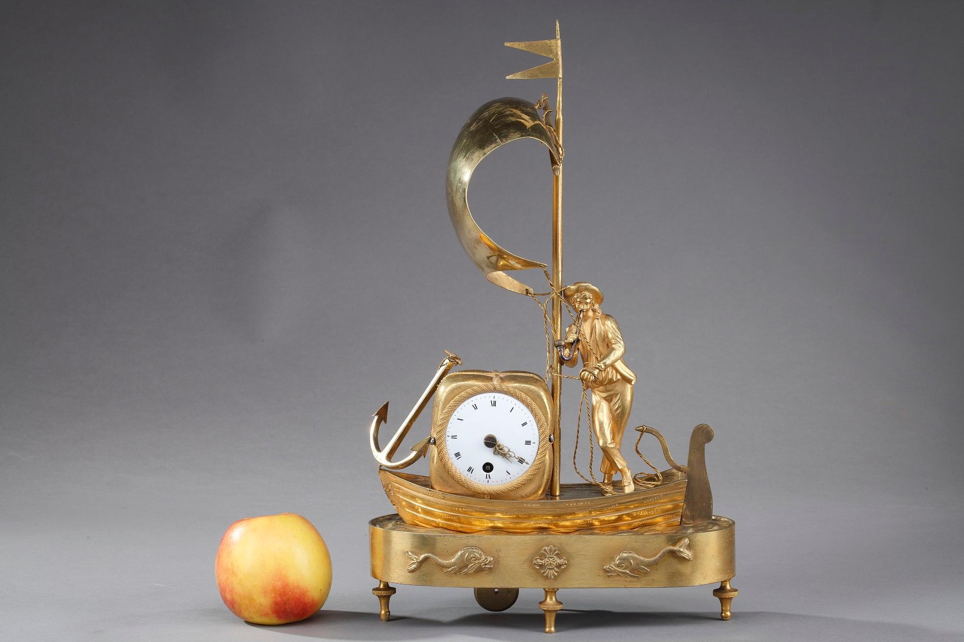 Small mantel clock The Sailor crafted of ormolu, or gilt bronze, in the early 19th century, featuring a European sailor carrying a bale of cotton on the sea. The round enamel dial features Roman numeral hours, indicated by means of two pierced gilt