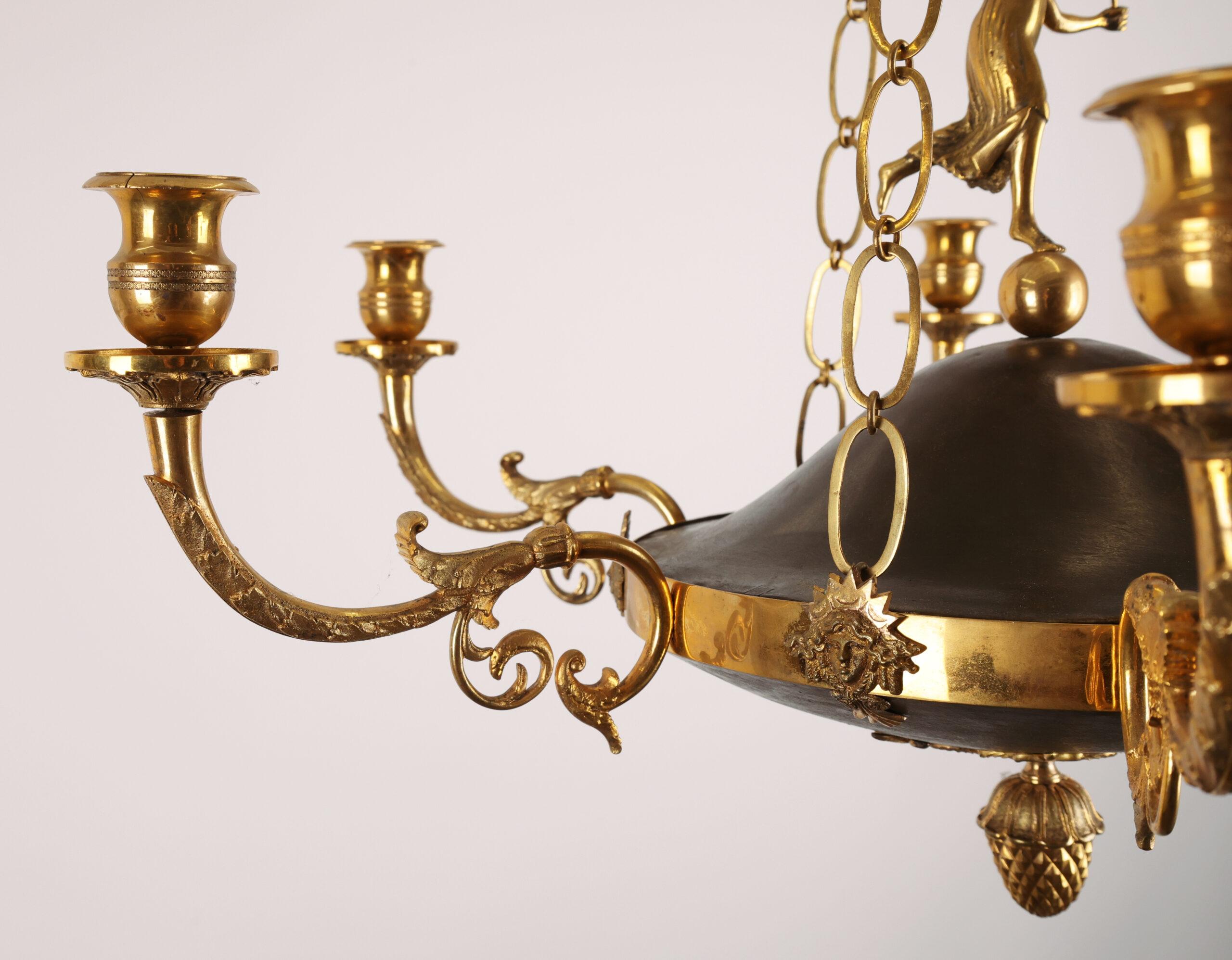 Pendente Impero di alta classe proveniente da Stoccolma intorno al 1800-1810. Presenta sei bracci di candela splendidamente decorati con foglie d'acanto. La decorazione centrale comprende una figura femminile in piedi su una sfera. Tre catene