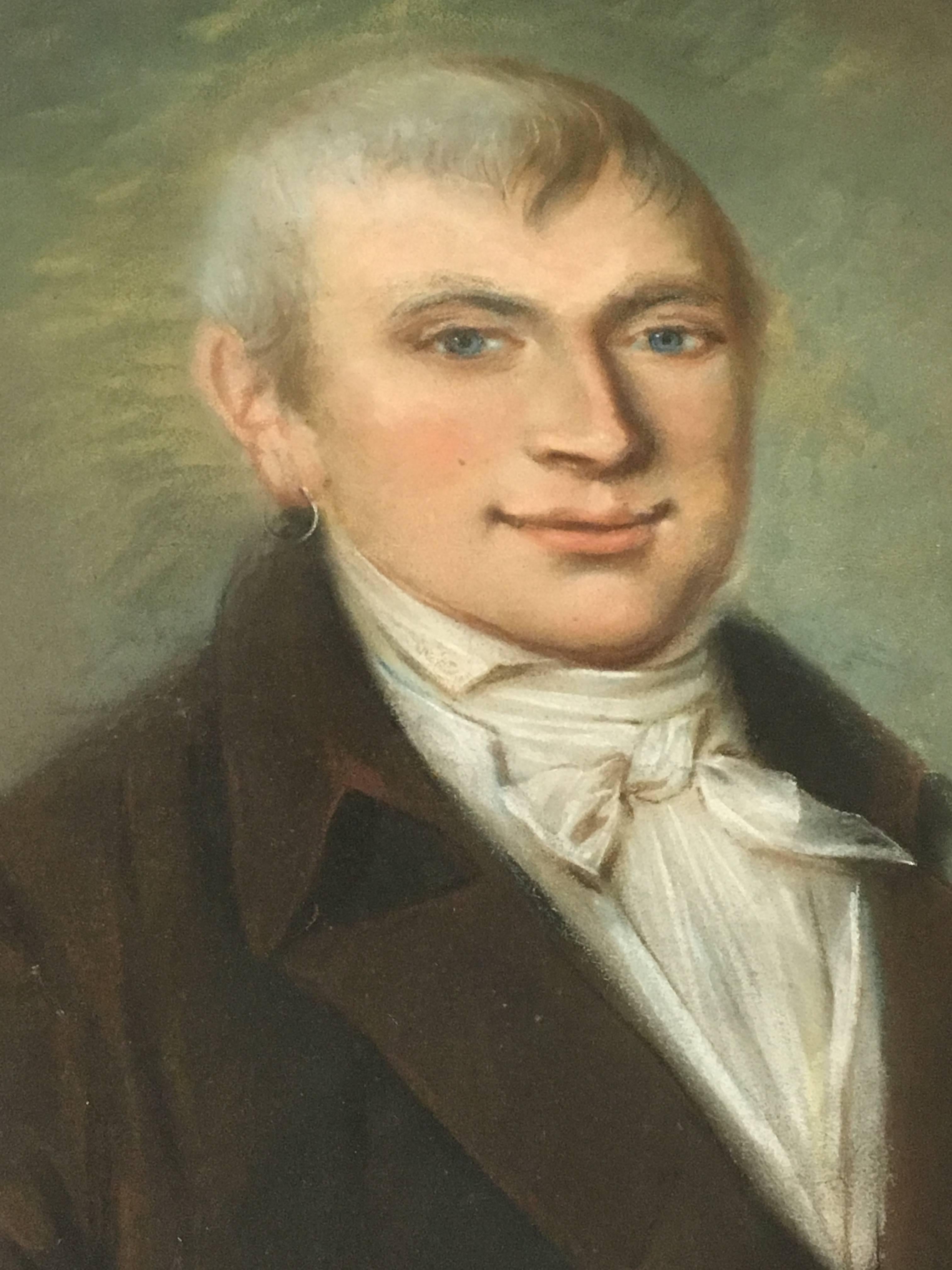 A charming portrait of a young Empire period gentleman with an earring, under glass in a period gild wood frame. Oil pastel on paper, French, circa 1800.