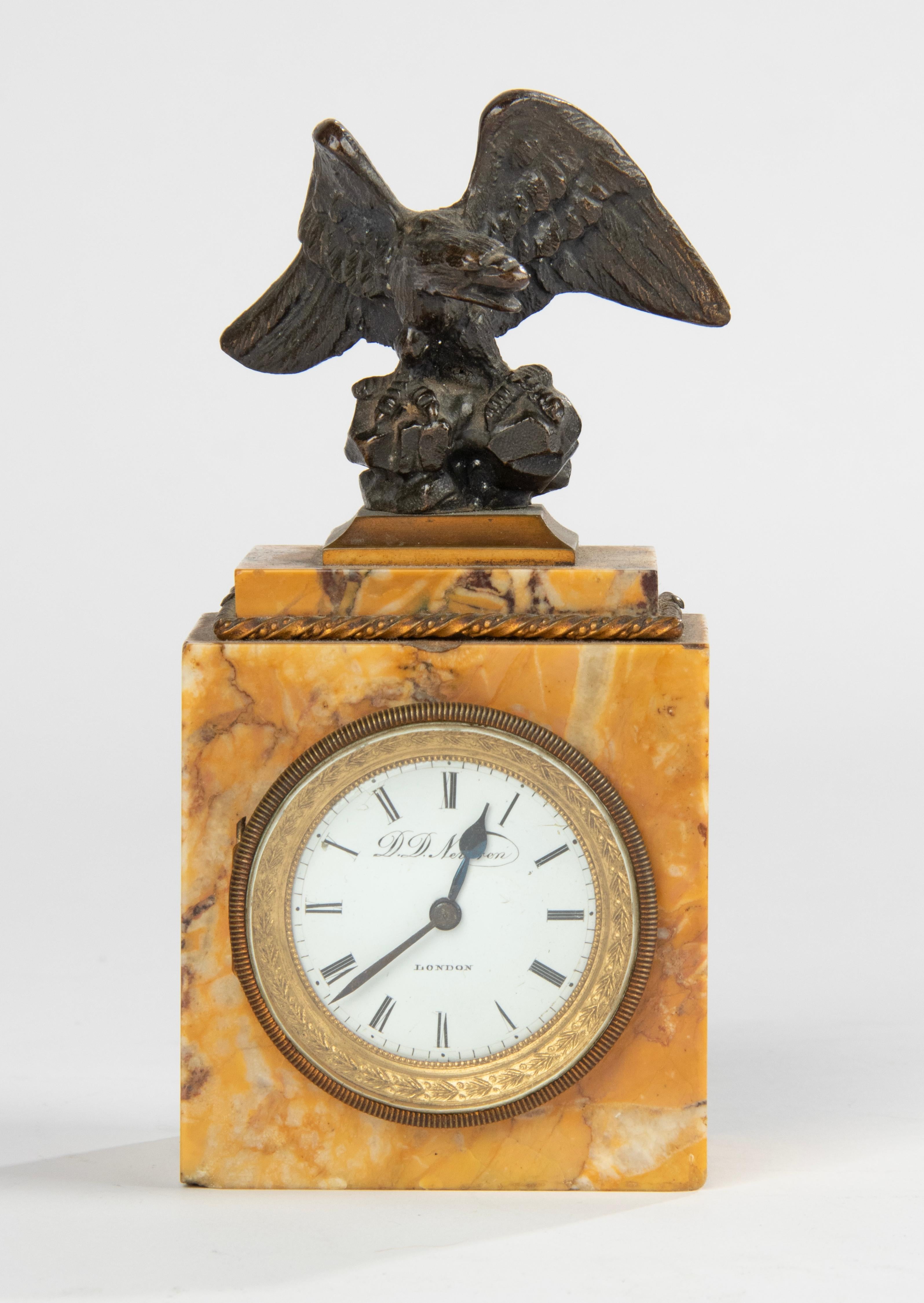A small and elegant desk clock from the Empire period. The case is made of Siena marble, on top of a patinated bronze eagle, enameled hand-painted dial. The clockwork is made by from D.D. Neveren, a London watchmaker. The clock runs through an
