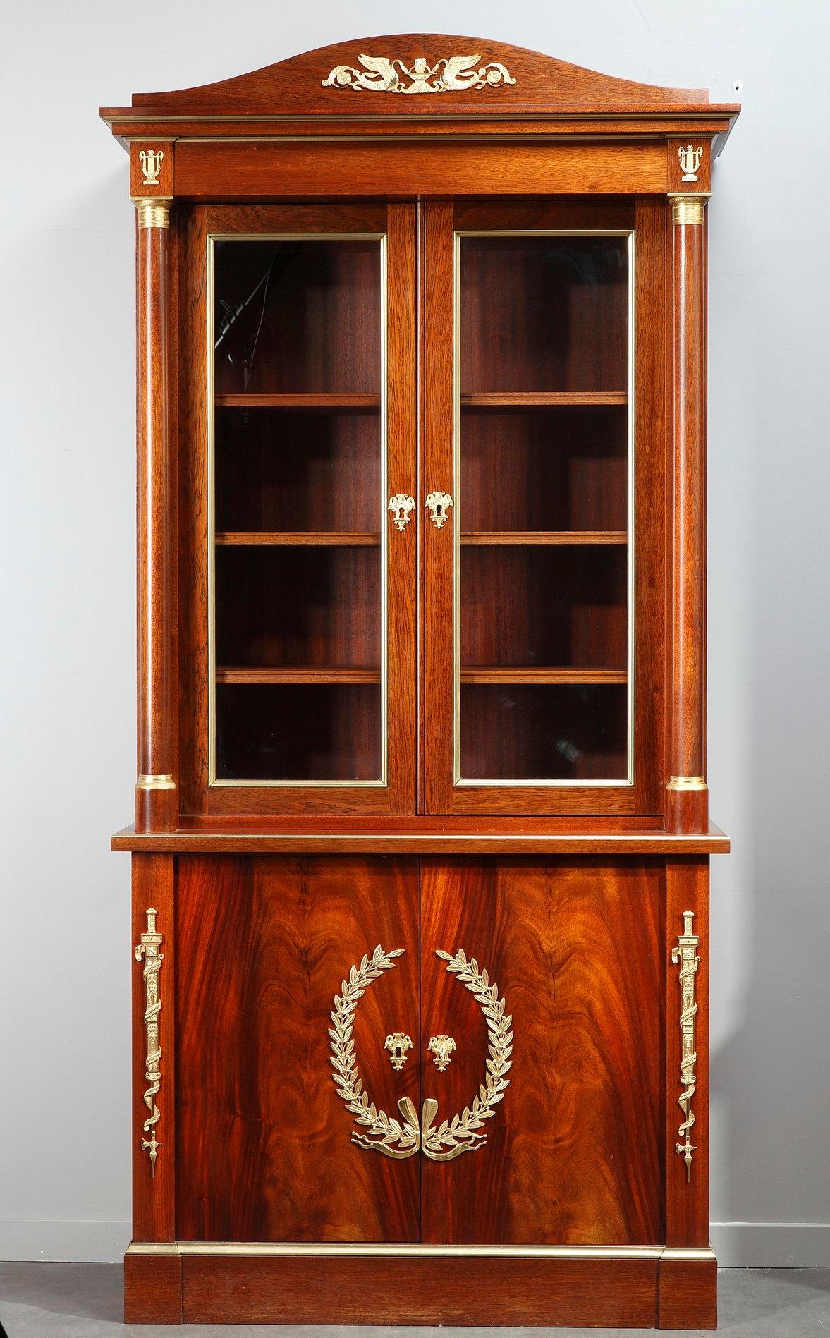 This monumental pair of Empire-style bookcases, or cabinets, was crafted in mahogany veneer by Maison Jansen (French, 1880-1989) in the mid-20th century.

Maison Jansen was renowned for his eclectic designs that blended the antique styles. Two