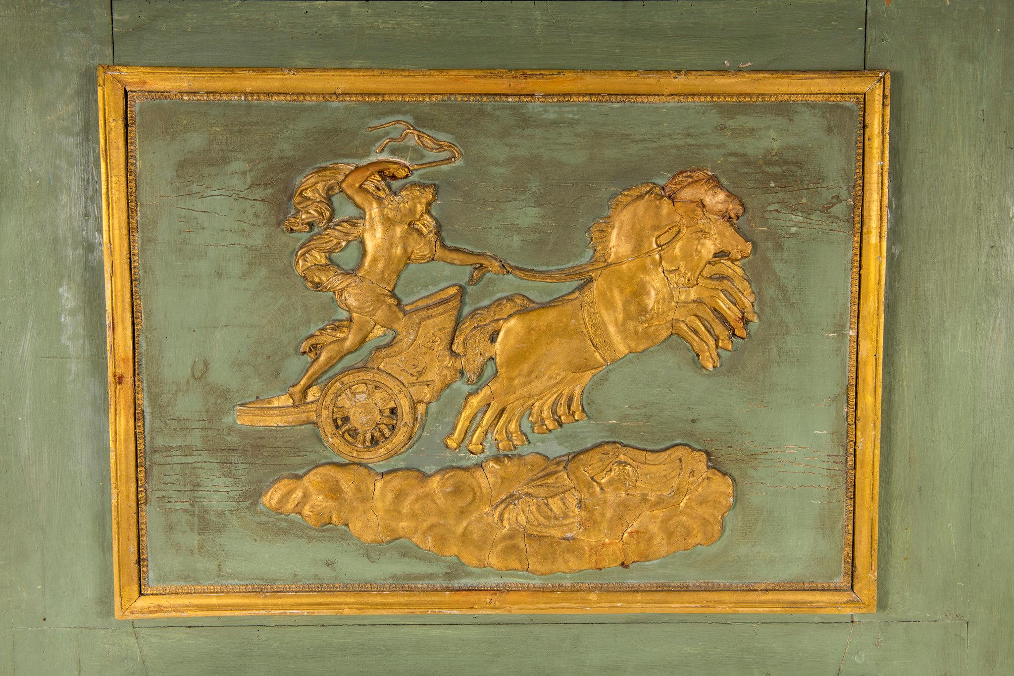 An early 19th century painted and parcel-gilt Empire trumeau mirror with horse and chariot scene.