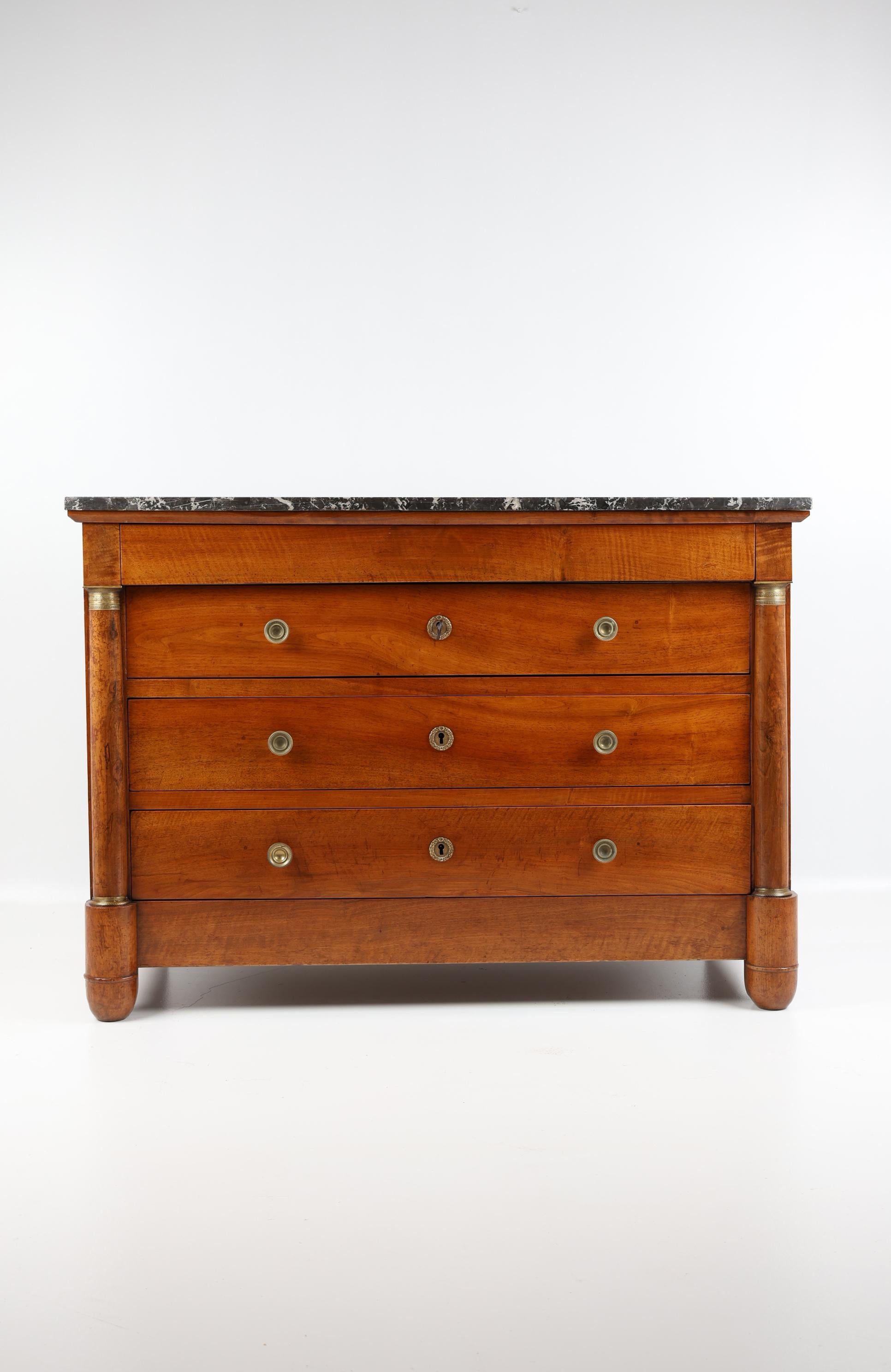 Cassettiera impero in noce del XIX secolo con piano in marmo
Francia, 1810
Noce

Antica cassettiera con marmo nero sul piano. Bellissima venatura di noce sulla parte anteriore e su entrambi i lati. Due classiche mezze colonne fiancheggiano la parte